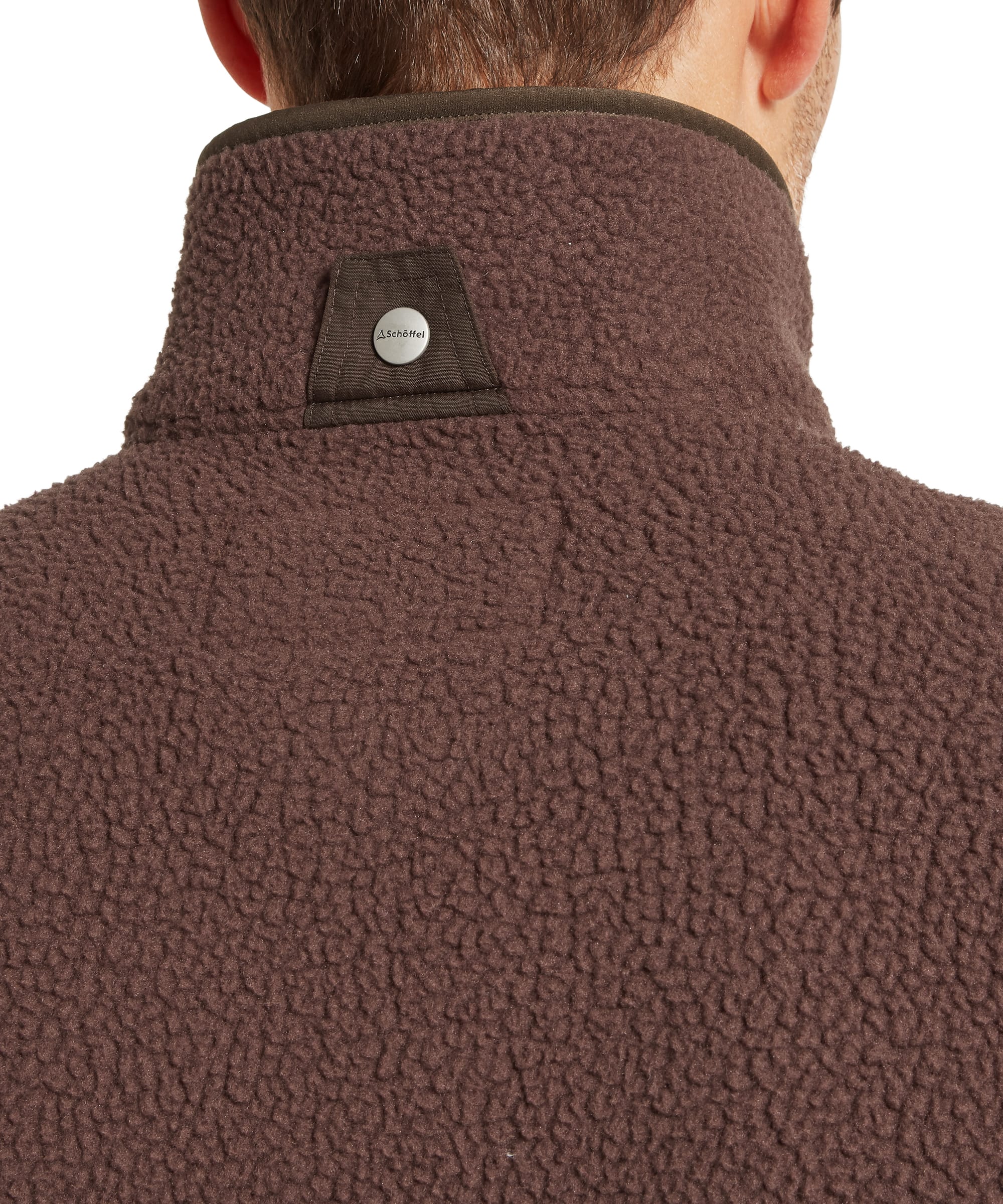 Close-up back neck detail of Schoffel Mens Oakham Retro Fleece Gilet in dark brown showing deep-pile textured sherpa fleece, contrast dark collar trim and Schoffel branded metal snap hanger loop