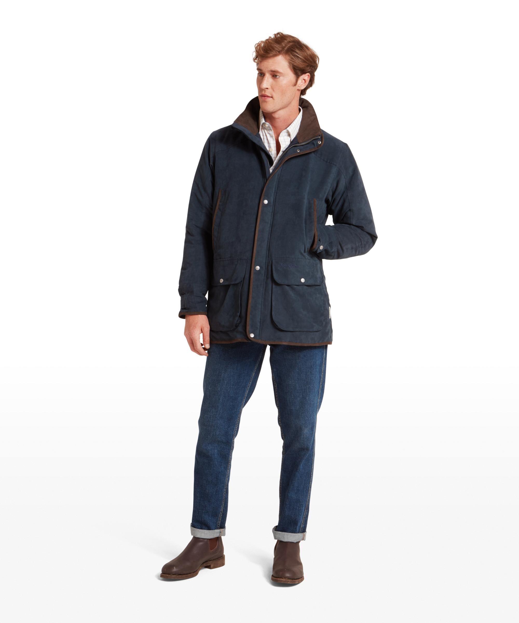 Man wearing a navy jacket, white shirt, and blue jeans on a white background