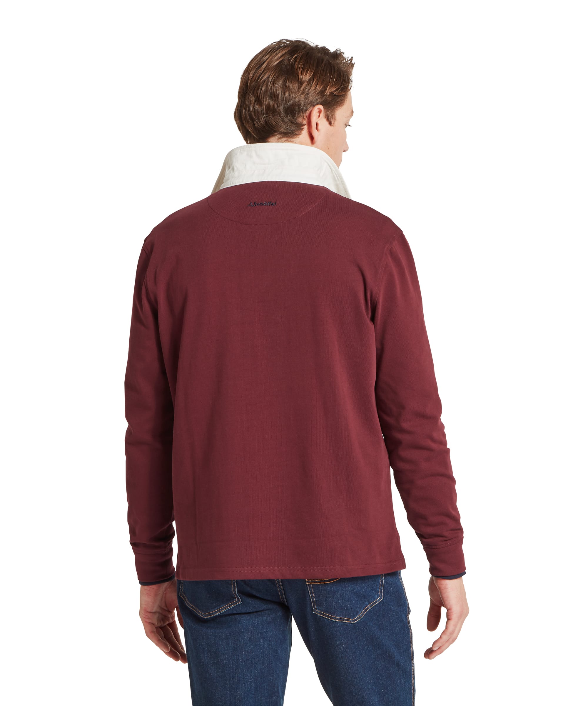 Schöffel Men's Porthallow Rugby Shirt in burgundy red — full-length front view styled with dark blue jeans, tan leather belt and navy Adidas Samba trainers