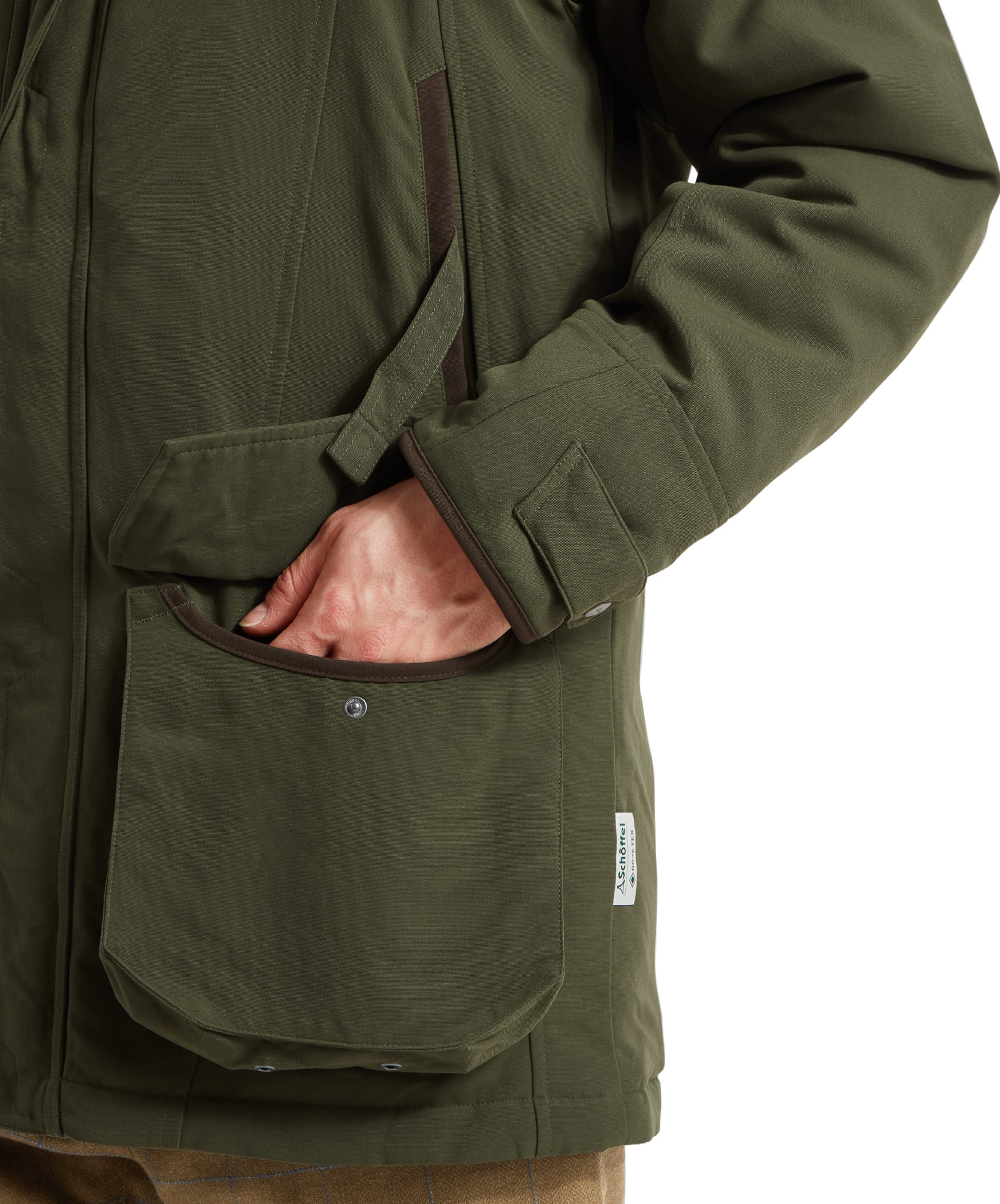 Schöffel Men's Ptarmigan Classic Coat in dark olive green — interior detail showing the large game/cartridge retainer pocket with zipped security compartment and mesh lining panel, coat held open over a checked shirt