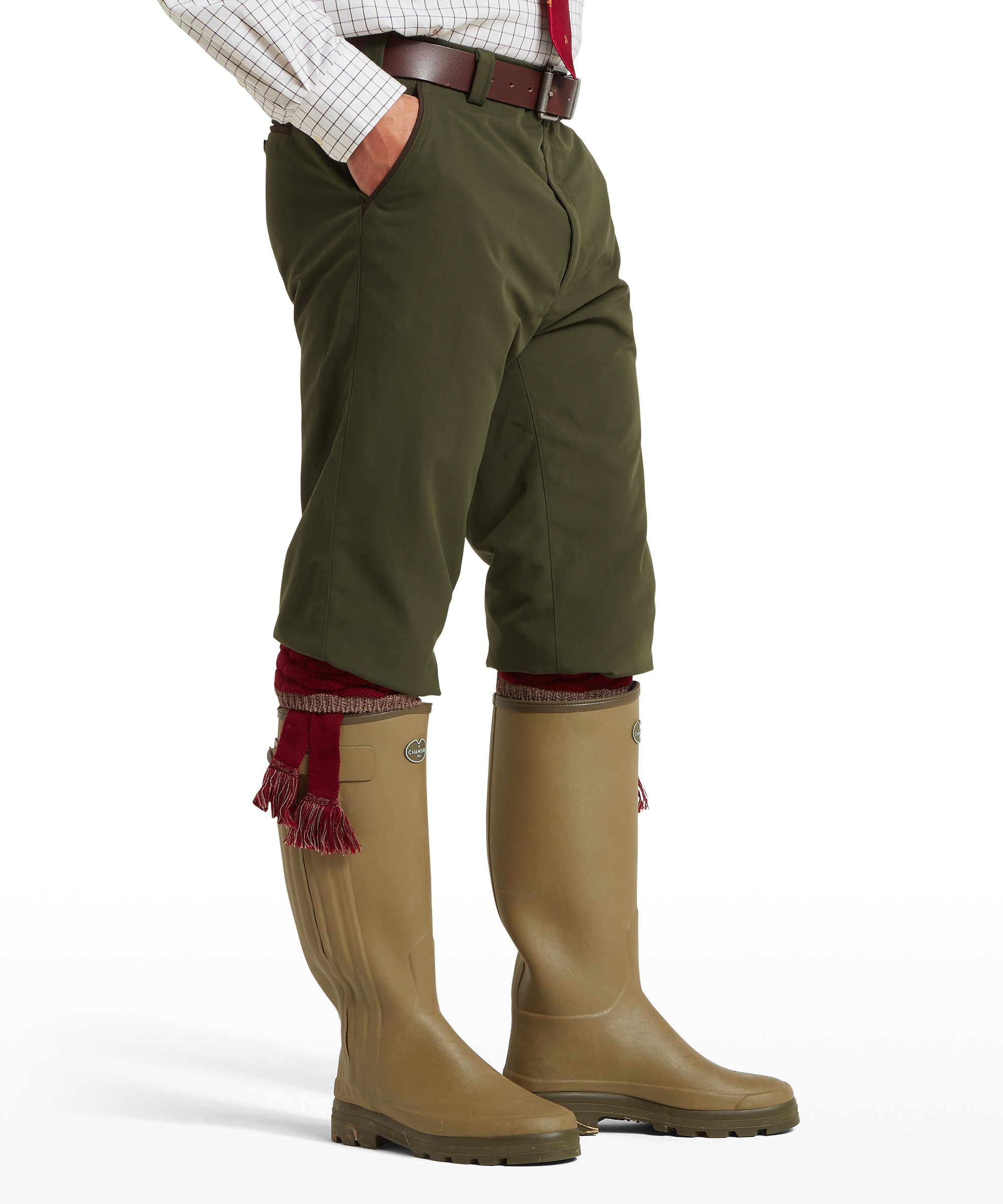 Side view of a man wearing Schöffel Ptarmigan Plus Twos breeks in green with brown leather belt and green wellington boots
