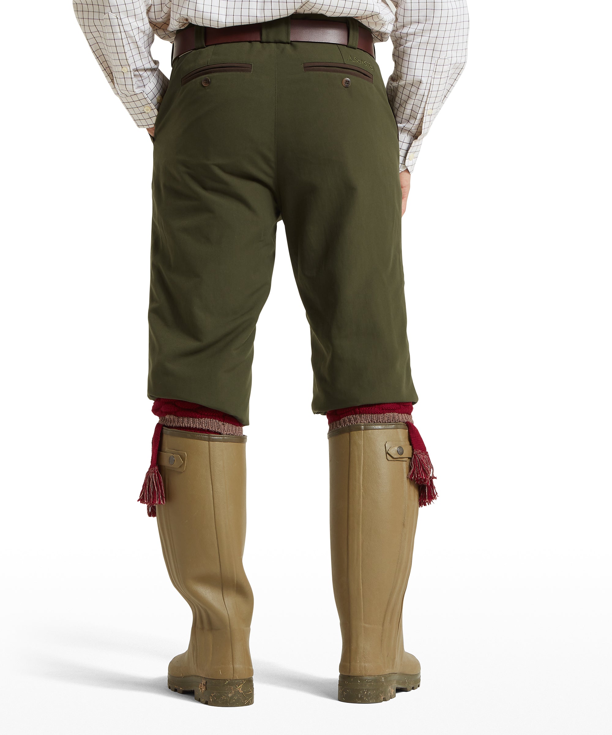 Rear view of a man wearing Schöffel Ptarmigan Plus Twos breeks in green with brown leather belt and green wellington boots