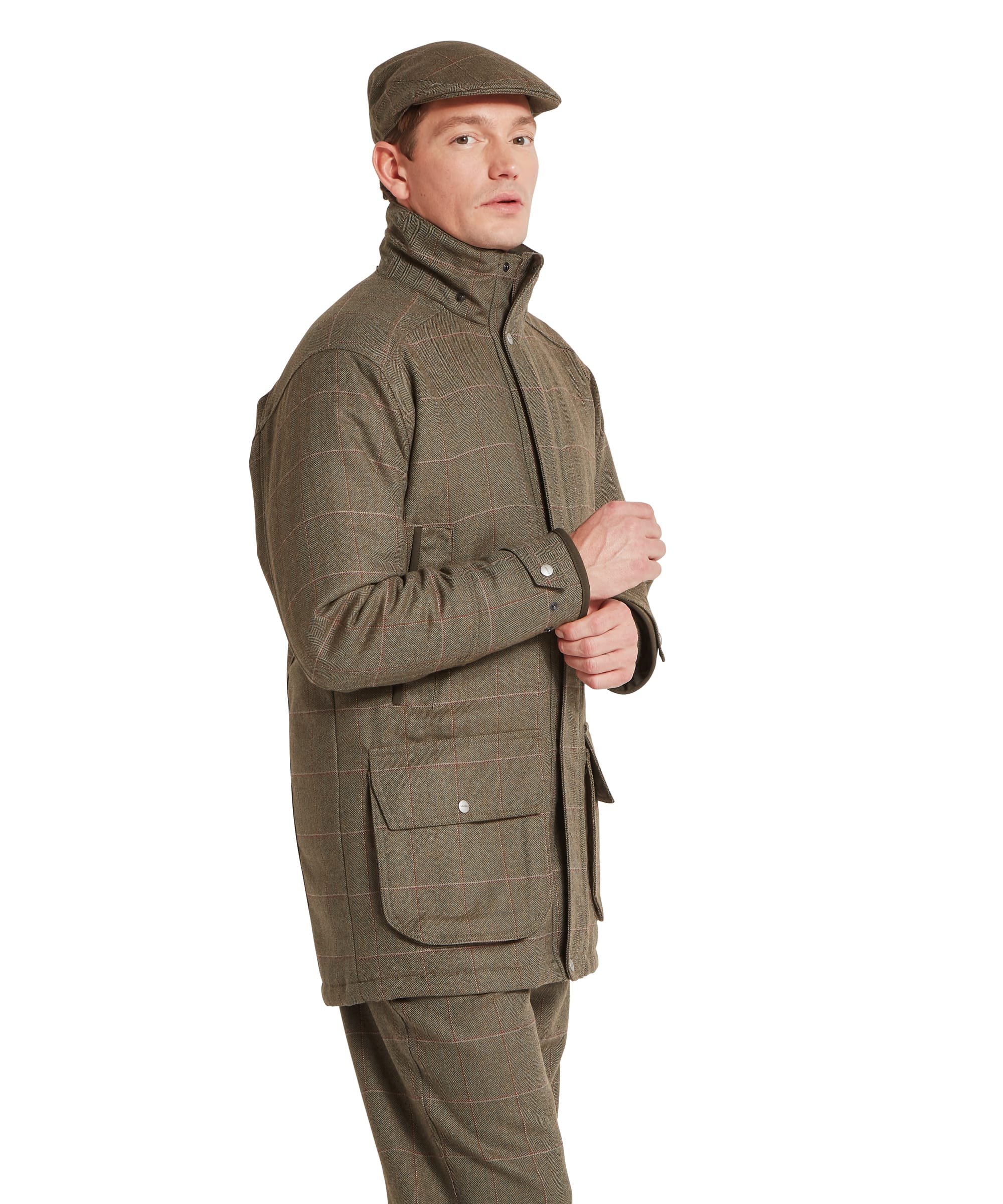 Schöffel Men's Ptarmigan Tweed Classic Coat in Lovat brown windowpane check — three-quarter front view showing the structured tweed coat silhouette, large bellows lower pockets with press-stud flaps, Schöffel branding and adjustable press-stud cuffs with olive binding, paired with matching tweed trousers and flat cap