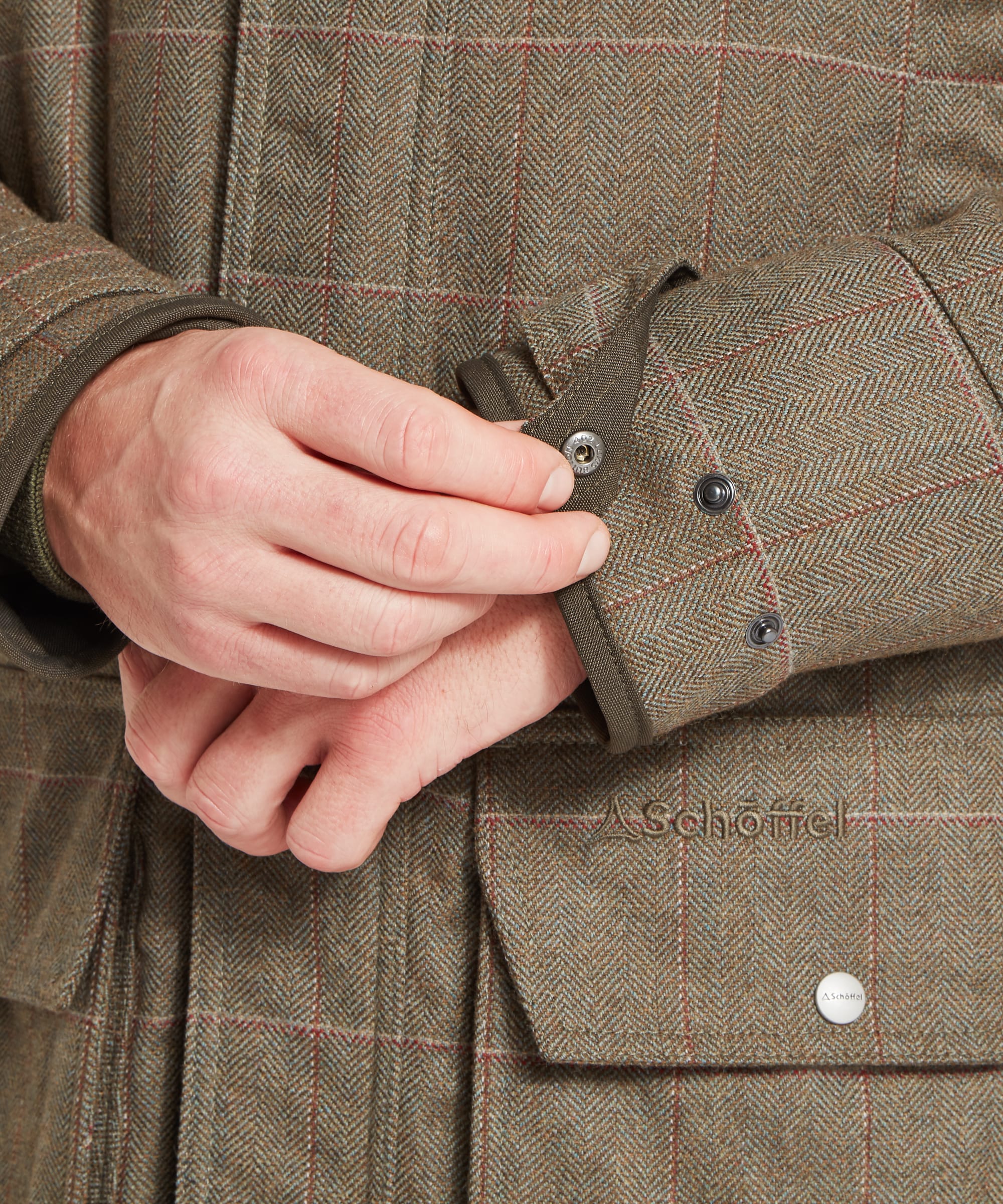 Schöffel Men's Ptarmigan Tweed Classic Coat in Lovat brown windowpane check — close-up of the large bellows lower pocket with open position showing depth, brown binding detail, press-stud flap and Schöffel Lochlane tweed fabric texture