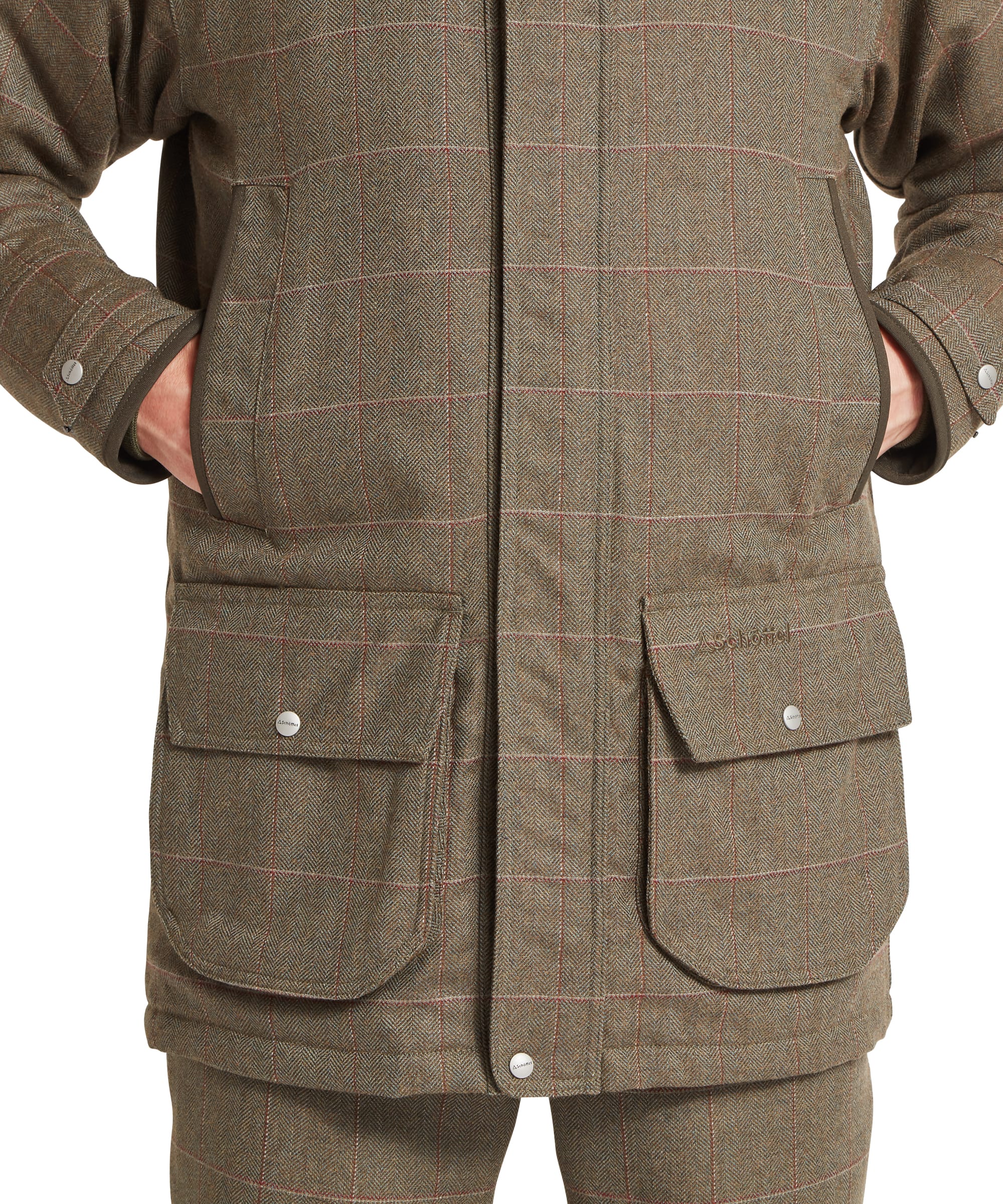 Schöffel Men's Ptarmigan Tweed Classic Coat in Lovat brown windowpane check — close-up of dual front zip fastening with Schöffel branded leather zip pull, wax cotton storm collar and press-stud placket, layered over a checked shirt and red tie