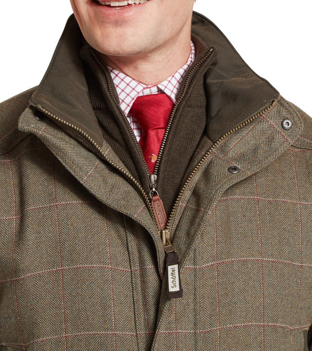 Schöffel Ptarmigan tweed classic coat in brown, close-up of herringbone check collar with contrast fleece-lined stand collar and full-length zip with branded pull tag, styled with shirt and tie