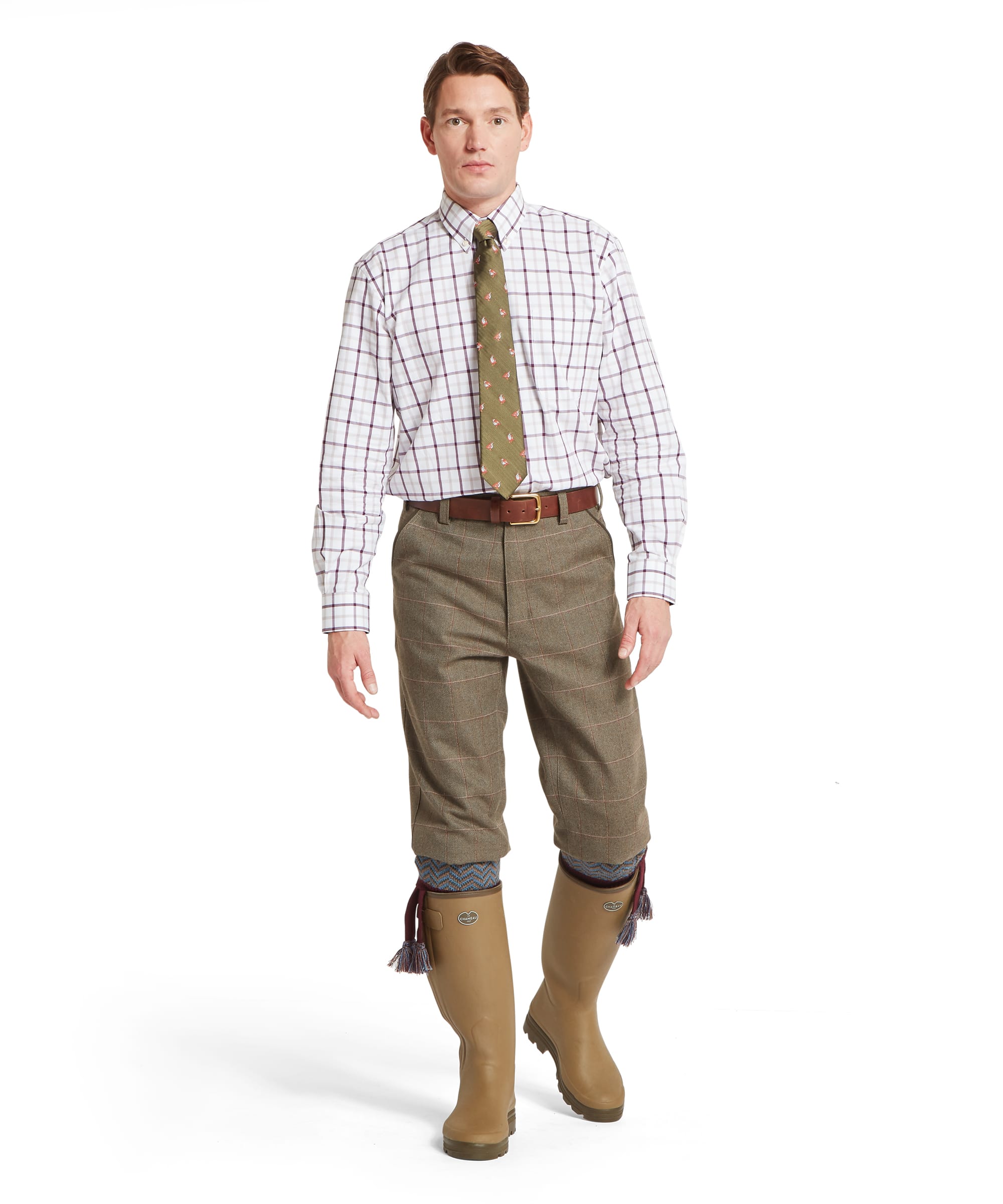 Schöffel Men's Ptarmigan Tweed Plus Twos in Lovat brown Lochlane windowpane check — front close-up showing the tailored waistband, Schöffel leather belt, front pleats and clean plus-two silhouette, worn with Le Chameau wellington boots and patterned sock garters