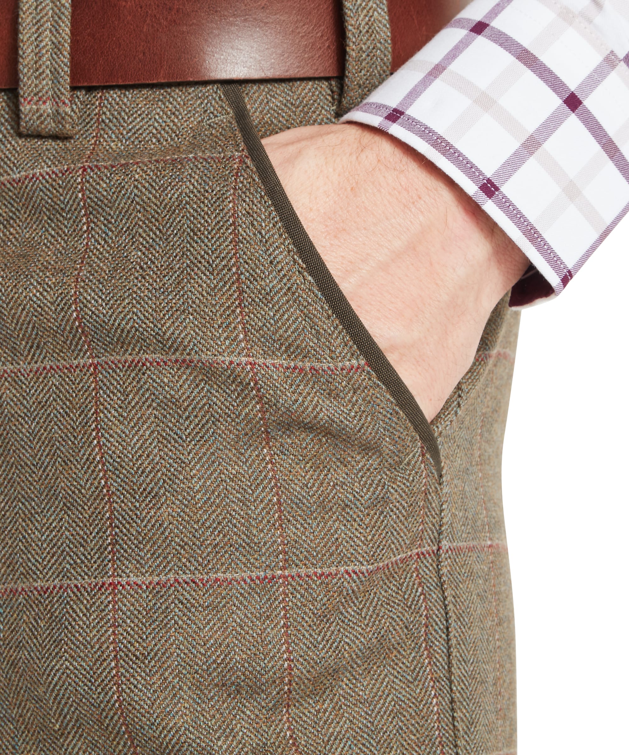 Schöffel Men's Ptarmigan Tweed Plus Twos in Lovat brown Lochlane windowpane check — close-up front detail showing the side seam pocket opening with brown grosgrain trim, belt loops, Schöffel leather belt and classic tweed herringbone fabric with red and buff windowpane overcheck