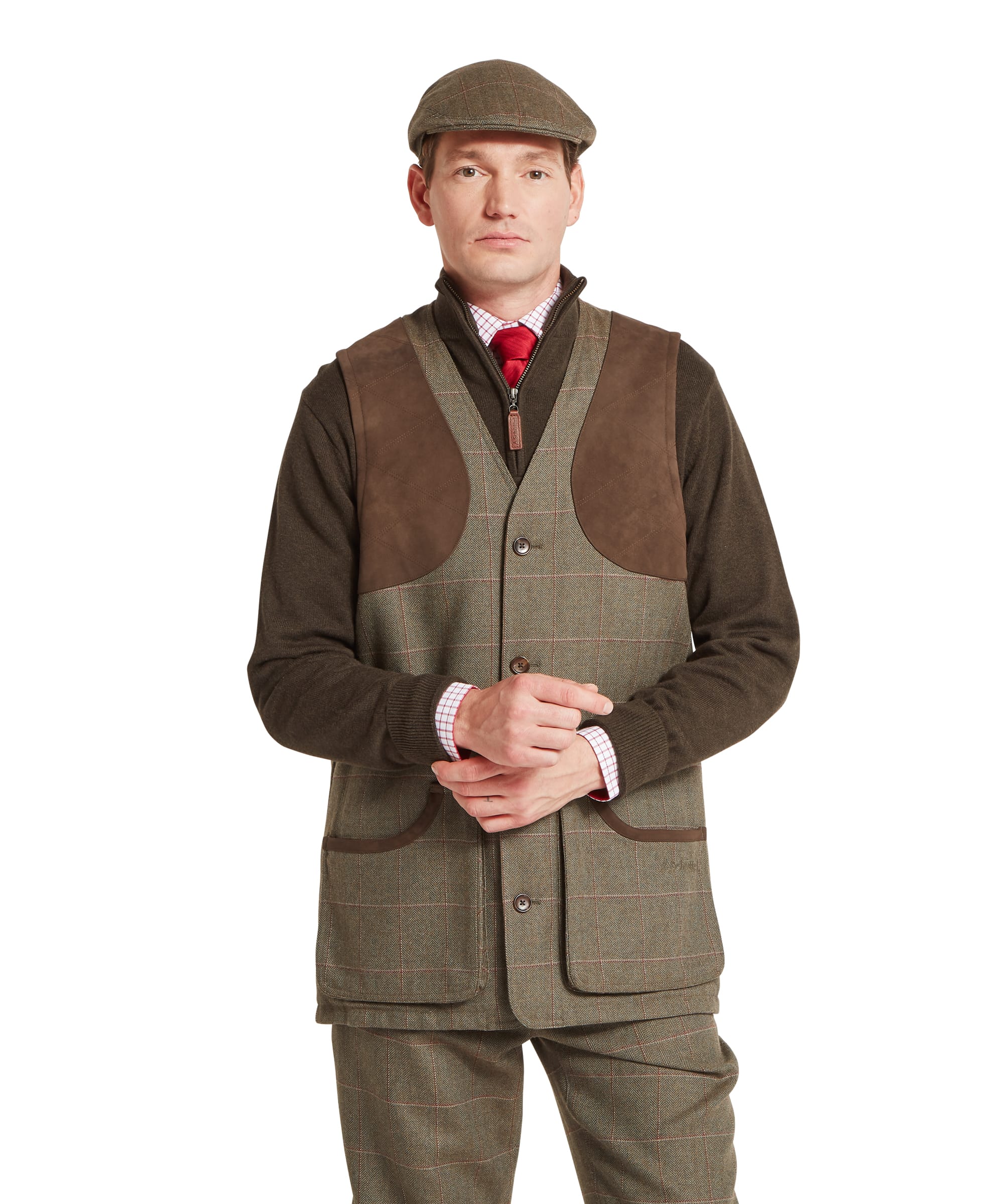 Schöffel Men's Ptarmigan Tweed Waistcoat II in Lovat brown windowpane check — front view showing tailored tweed body, large suede shooting patch panels, three-button front fastening, lower patch pockets with brown leather trim binding and Schöffel branding, layered over a zip-neck merino gilet, checked shirt and red tie, worn with matching tweed plus twos and a tweed flat cap