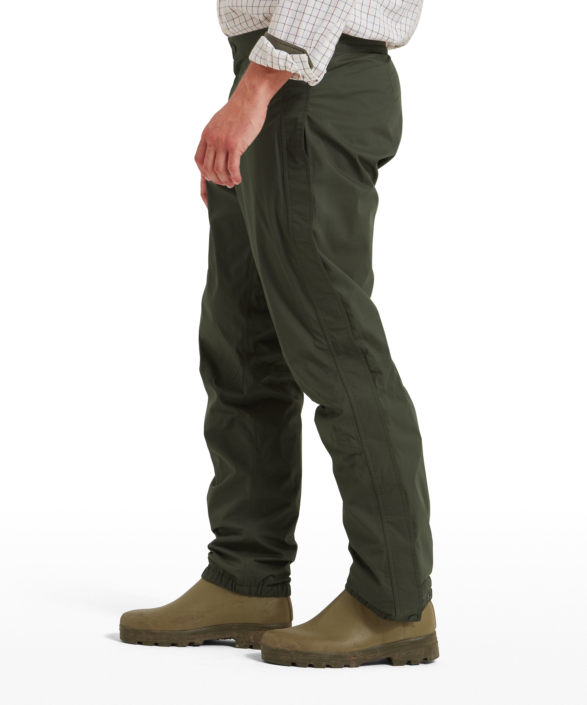 Schöffel Saxby men's overtrousers in green, side profile worn with wellington boots, showing full-length fit and side seam detail