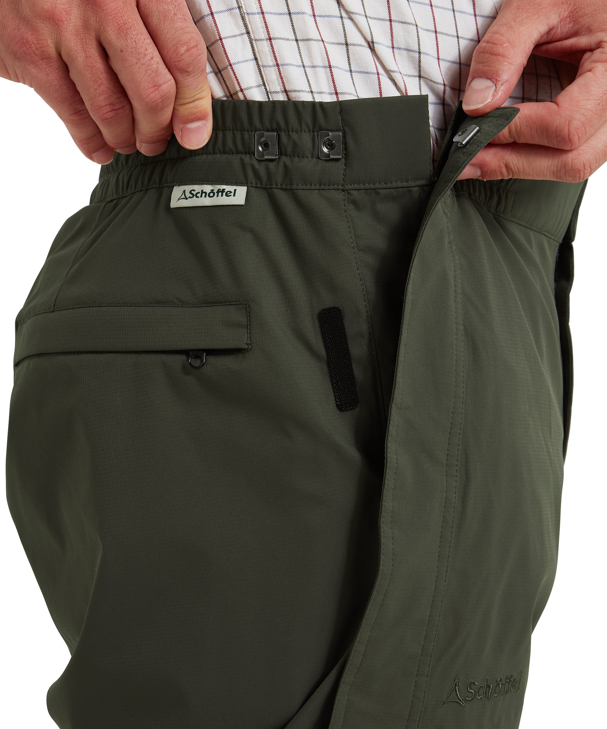 Schöffel Saxby men's overtrousers in green, close-up of adjustable waistband with popper fastening, hook-and-loop side adjuster and zipped side pocket