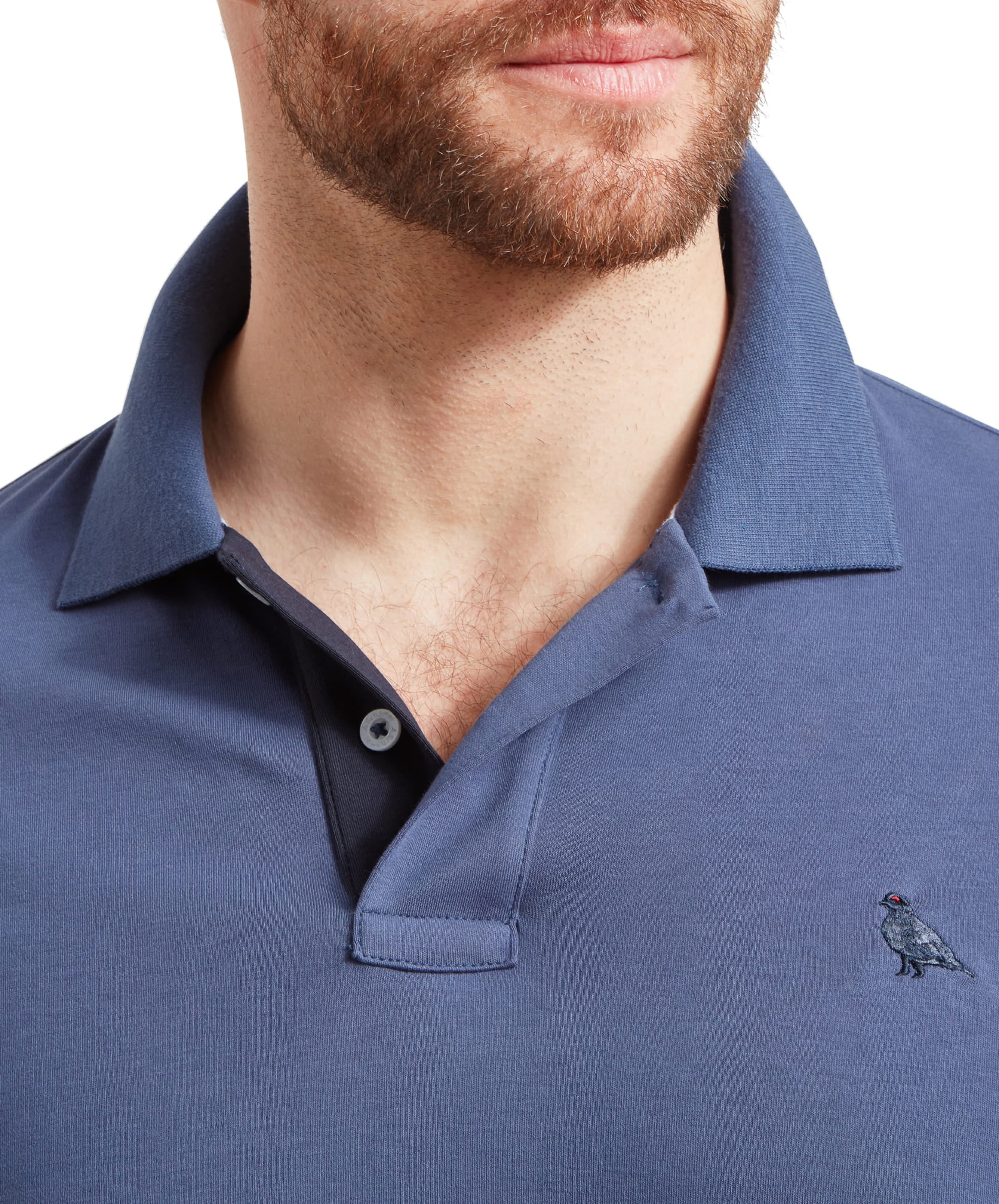 Schöffel Men's St Ives Jersey Polo Shirt in slate blue, close-up collar and placket detail on model showing embroidered grouse motif