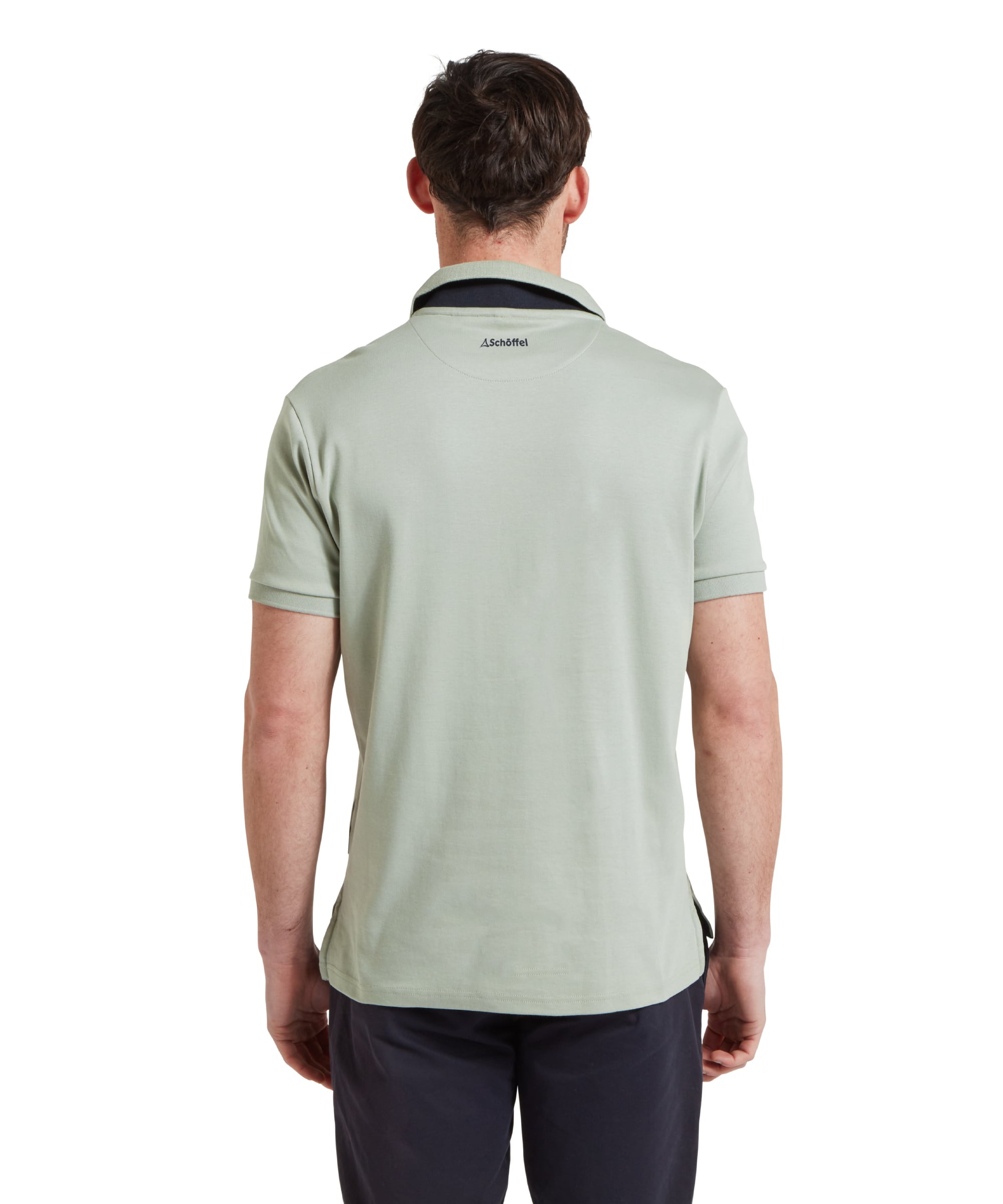 Schöffel Men's St Ives Jersey Polo Shirt in sage green, back view on model showing Schöffel neck branding, styled with navy trousers