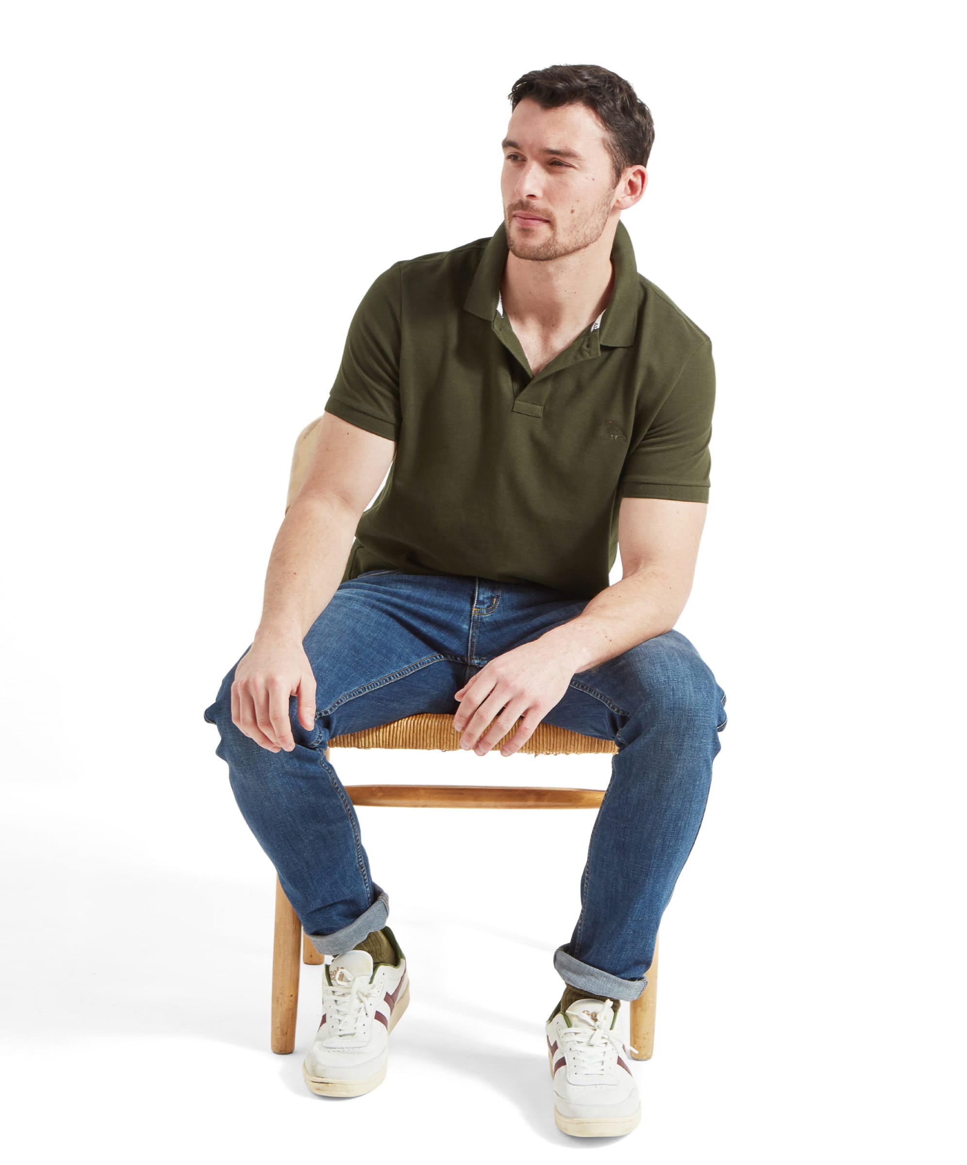 Schöffel Men's St Ives Polo Shirt in olive green, full-length seated view on model paired with denim jeans and trainers