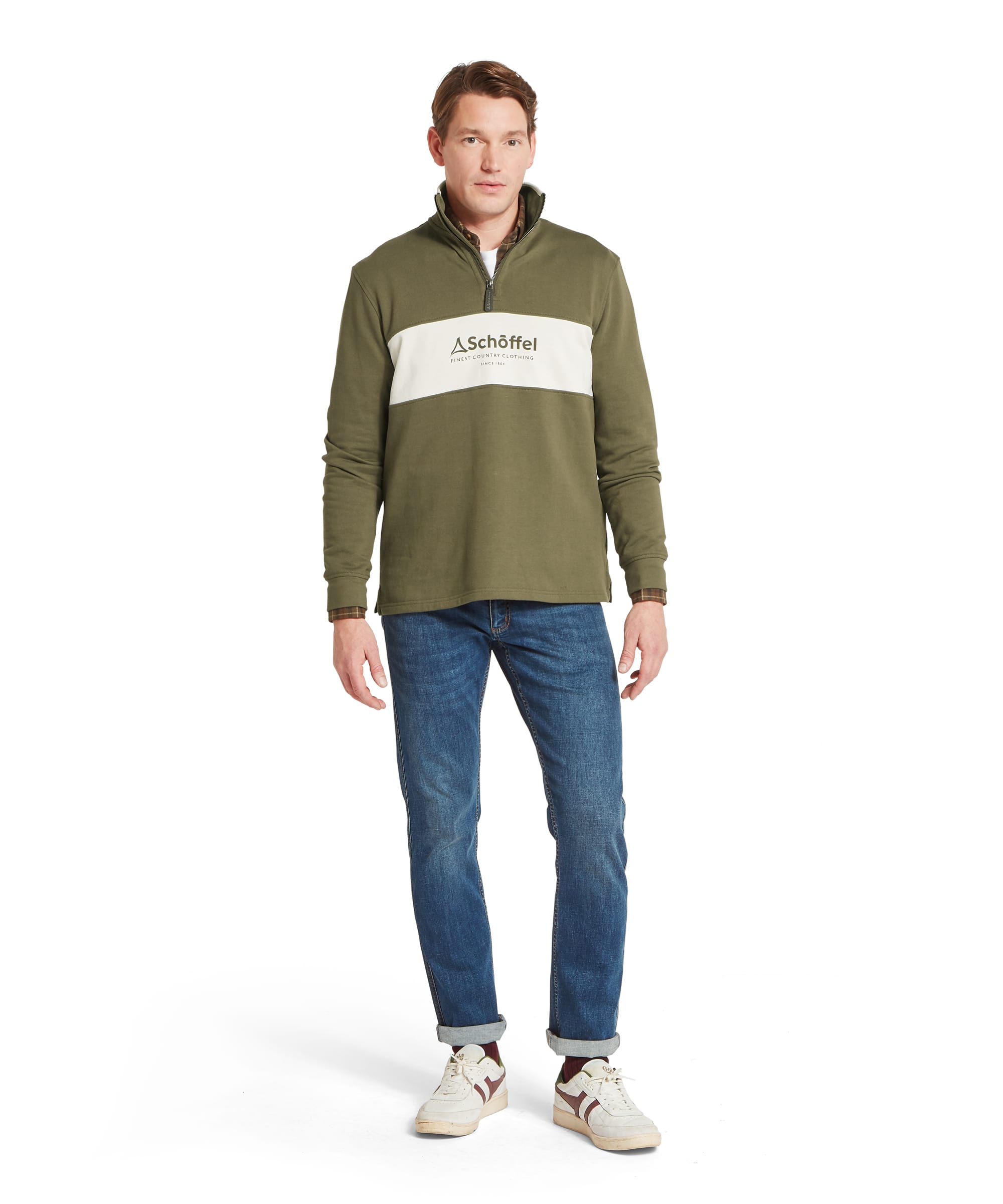 Schöffel Men's Trencrom ¼ Zip in olive green — full-length front view showing the relaxed fit, colour-block construction, ribbed cuffs and hem, styled with blue jeans and white Gola-style trainers