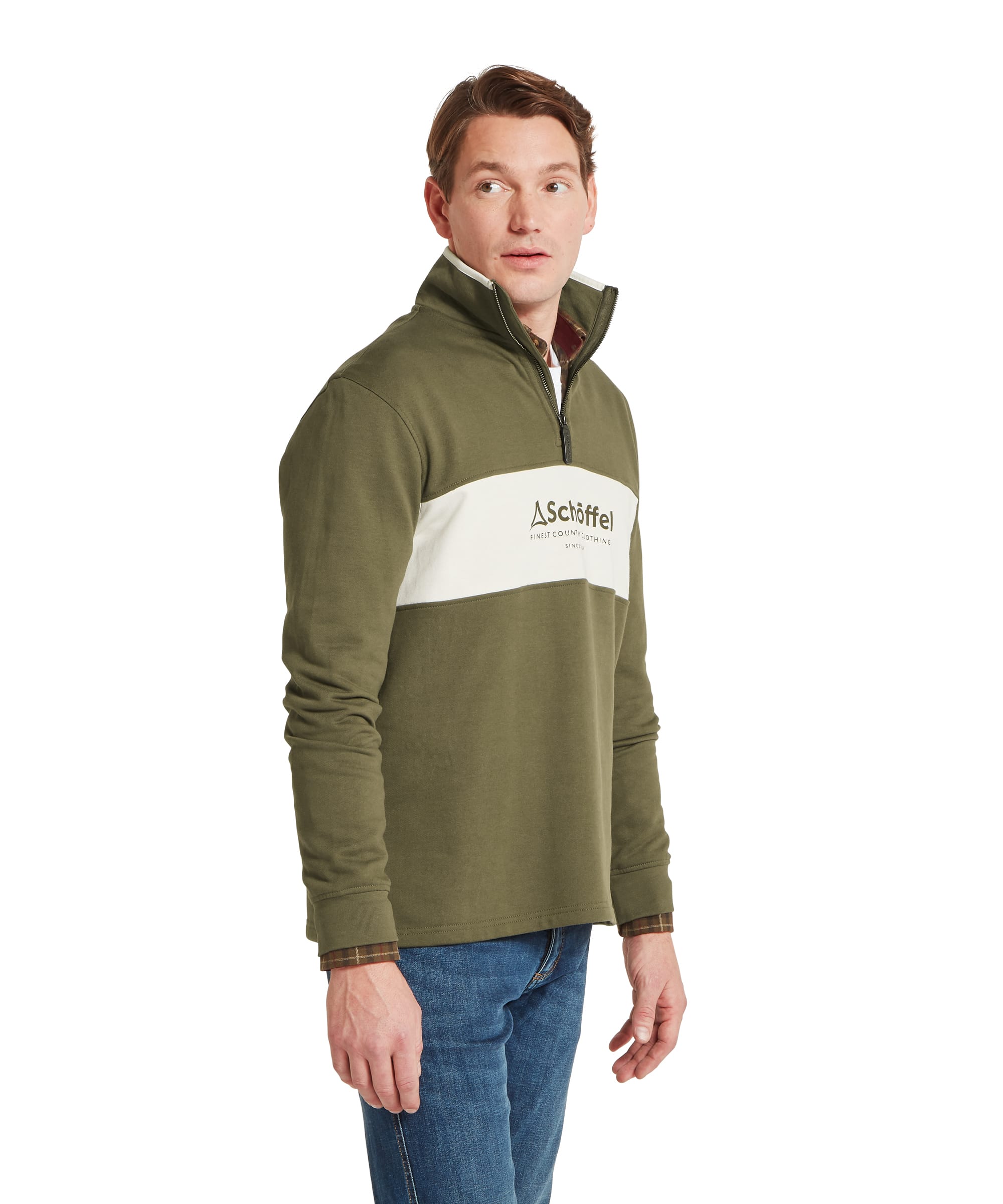 Schöffel Men's Trencrom ¼ Zip in olive green — three-quarter front view showing colour-block olive and ecru design with Schöffel heritage logo on the chest panel, quarter-zip stand collar and ribbed cuffs, layered over a checked shirt with blue jeans