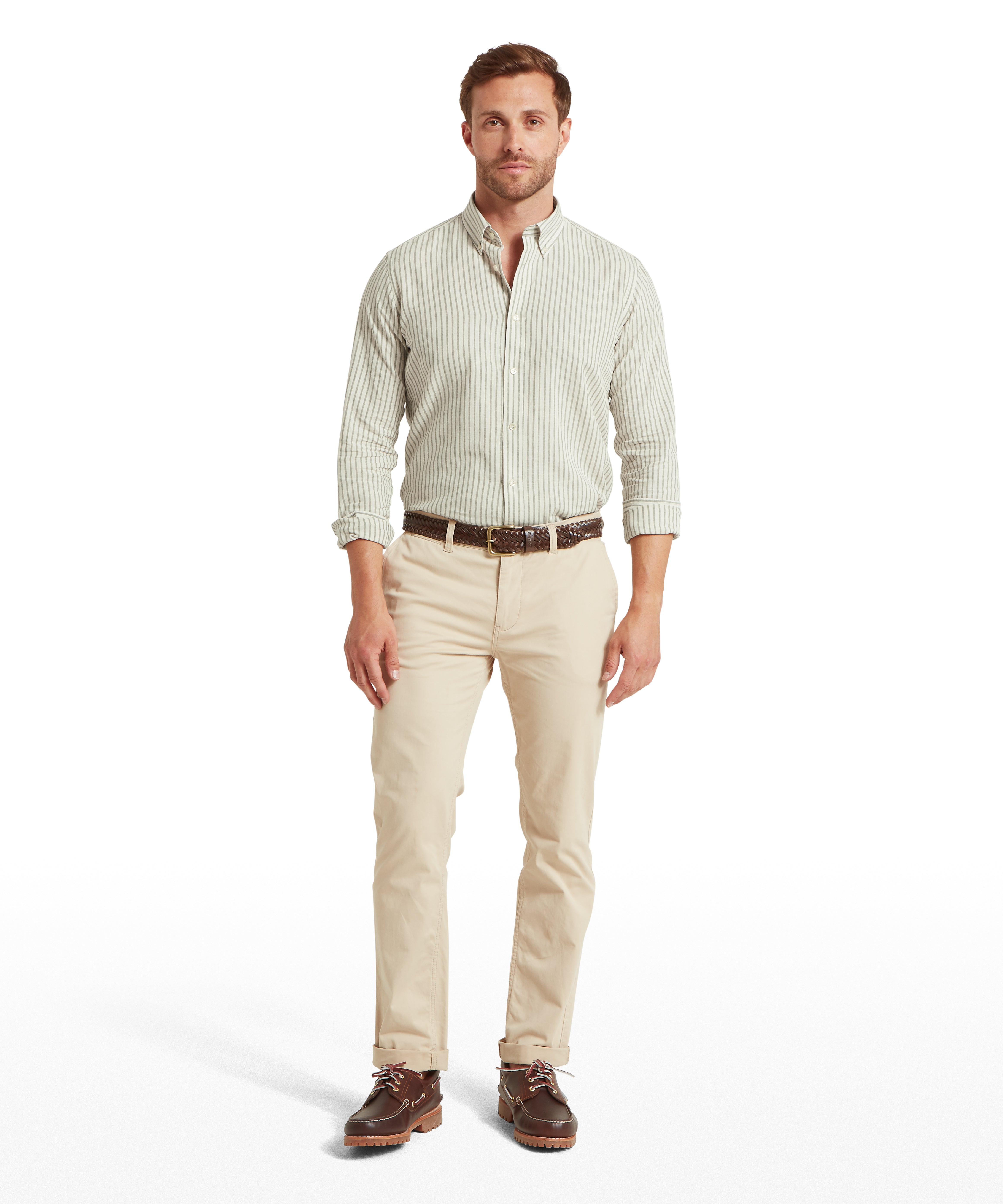 Man wearing a light green checked shirt, beige trousers, and brown shoes on a white background.  The man is facing forwards and has both hands by his side.