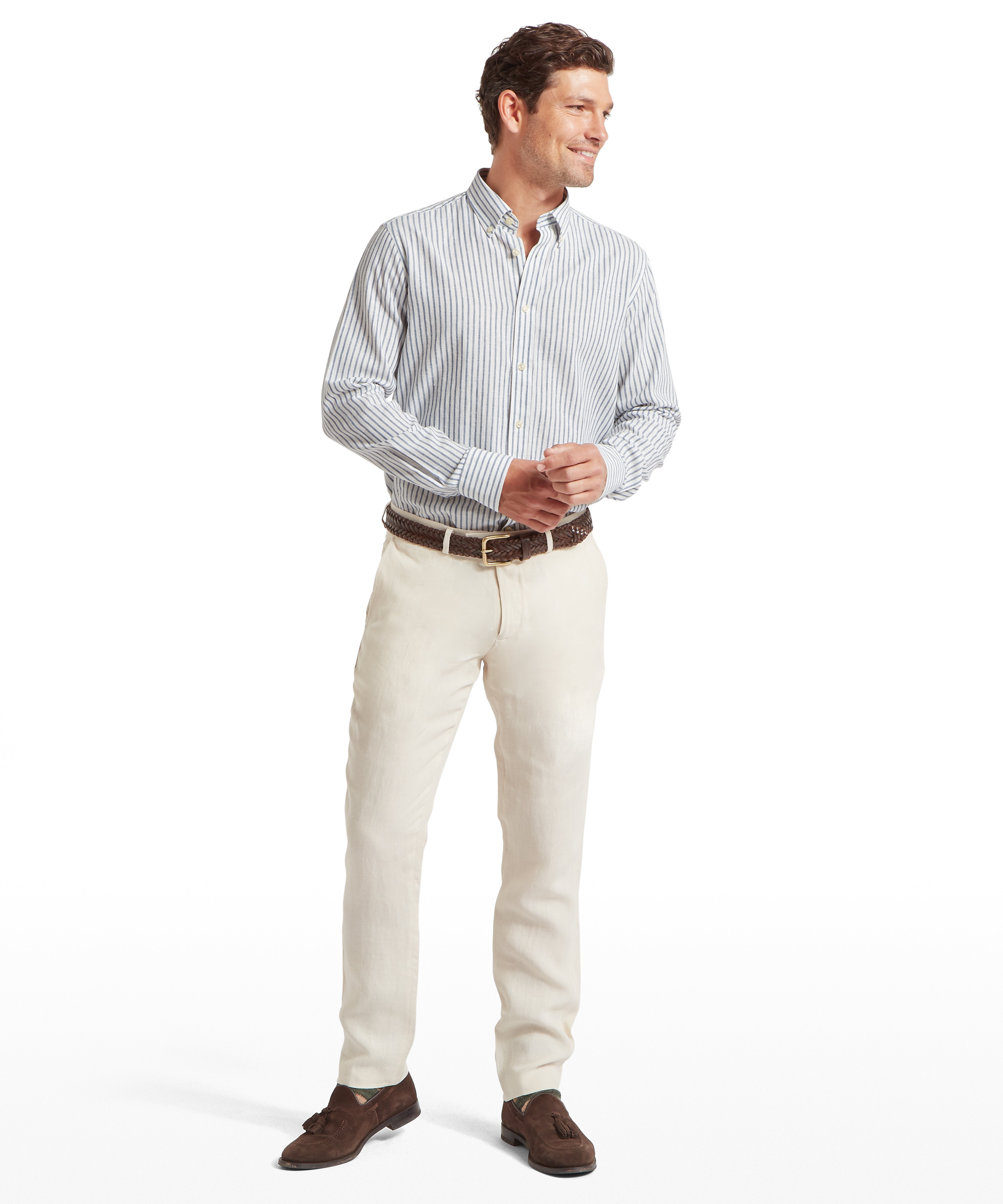 Man wearing a striped shirt, beige trousers, and brown shoes against a white background