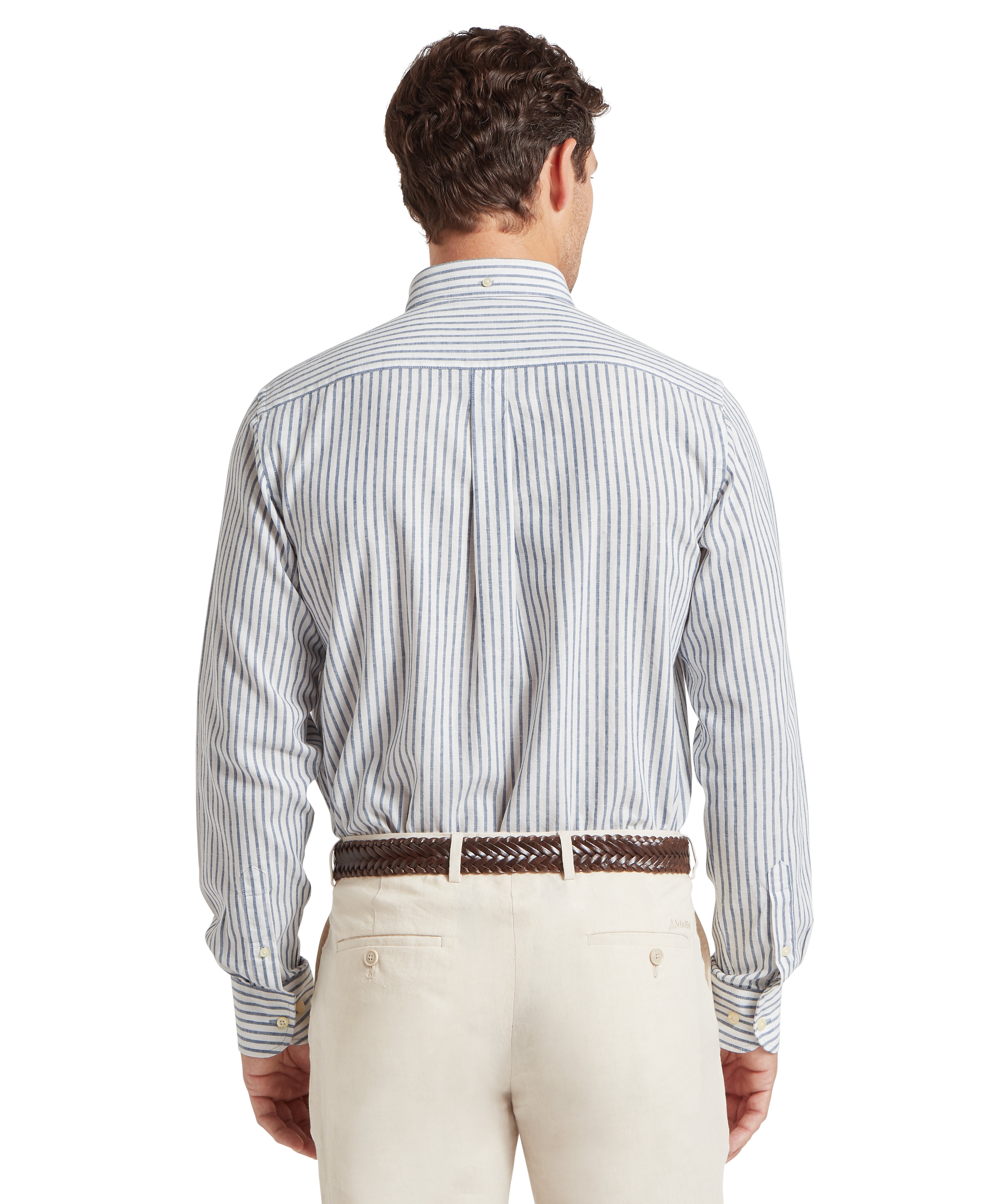 Man wearing a striped linen shirt and beige trousers standing backwards against a white background