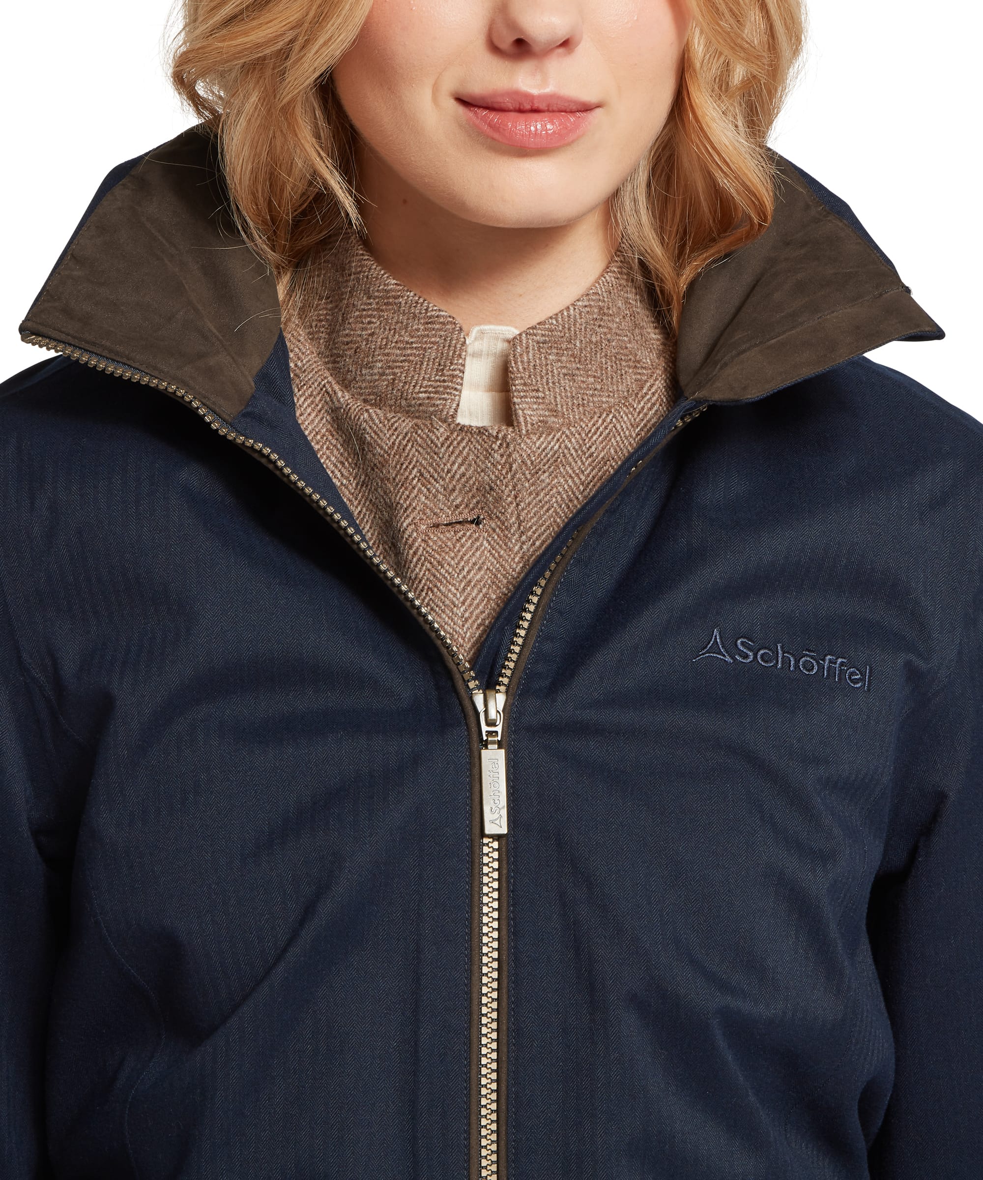 Close-up of the Schöffel Women's Allexton Waterproof Coat collar and zip fastening in navy, showing the herringbone fabric texture, brown suede-effect inner collar and embroidered Schöffel logo on the chest