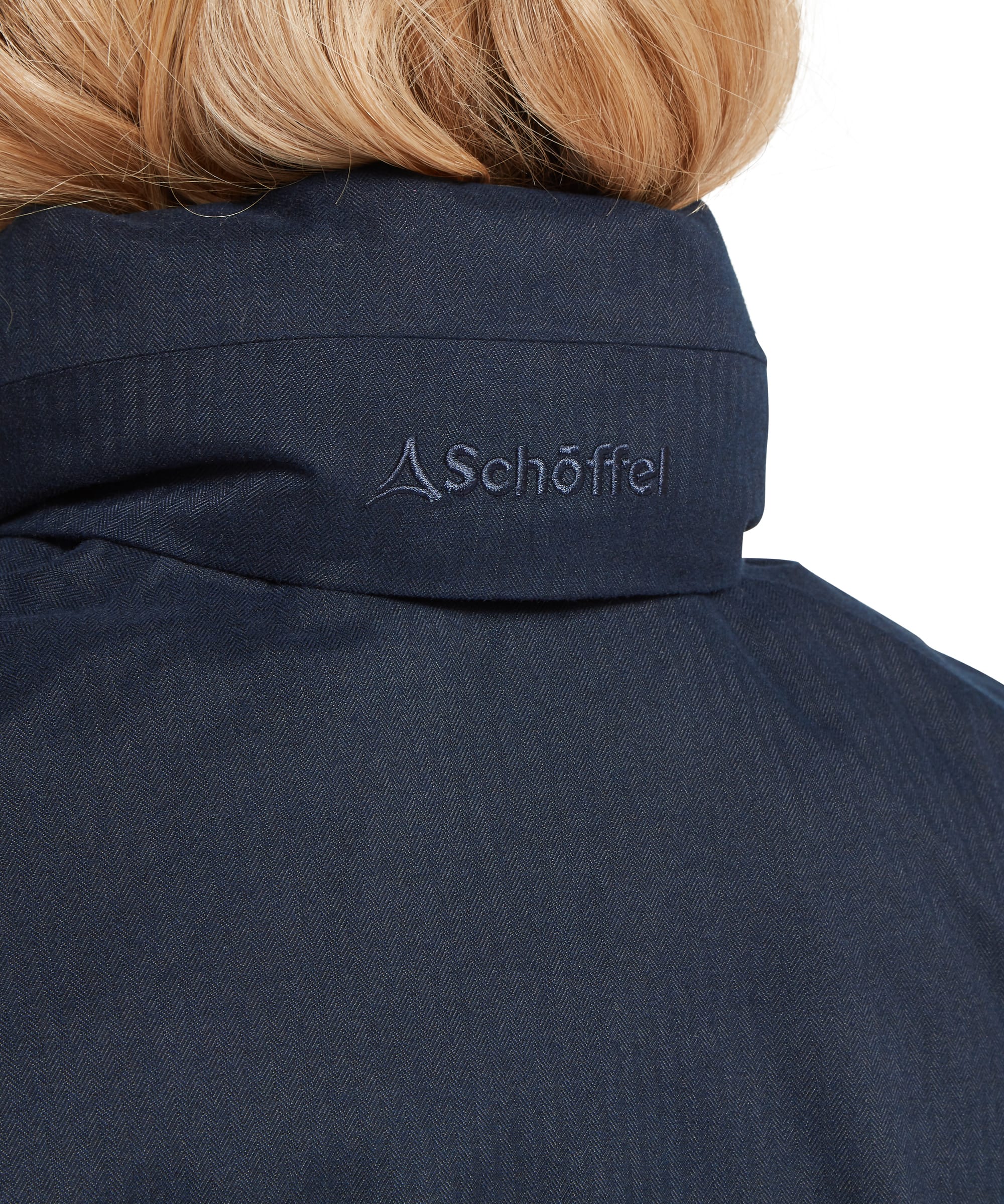 Rear collar detail of the Schöffel Women's Allexton Waterproof Coat in navy herringbone fabric, with embroidered Schöffel logo and structured stand collar