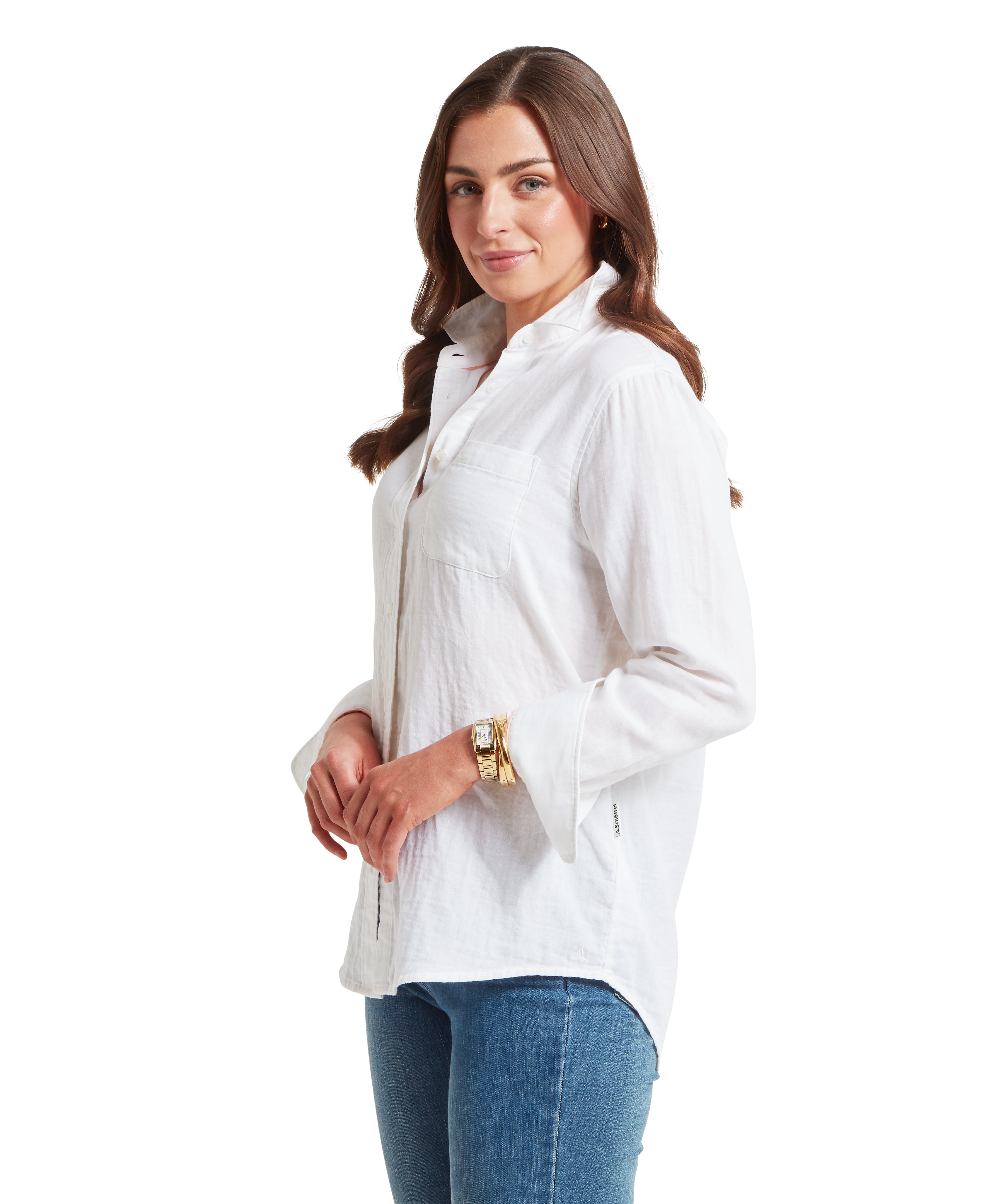 Woman wearing a white shirt and blue jeans on a white background.  The woman is standing sideways