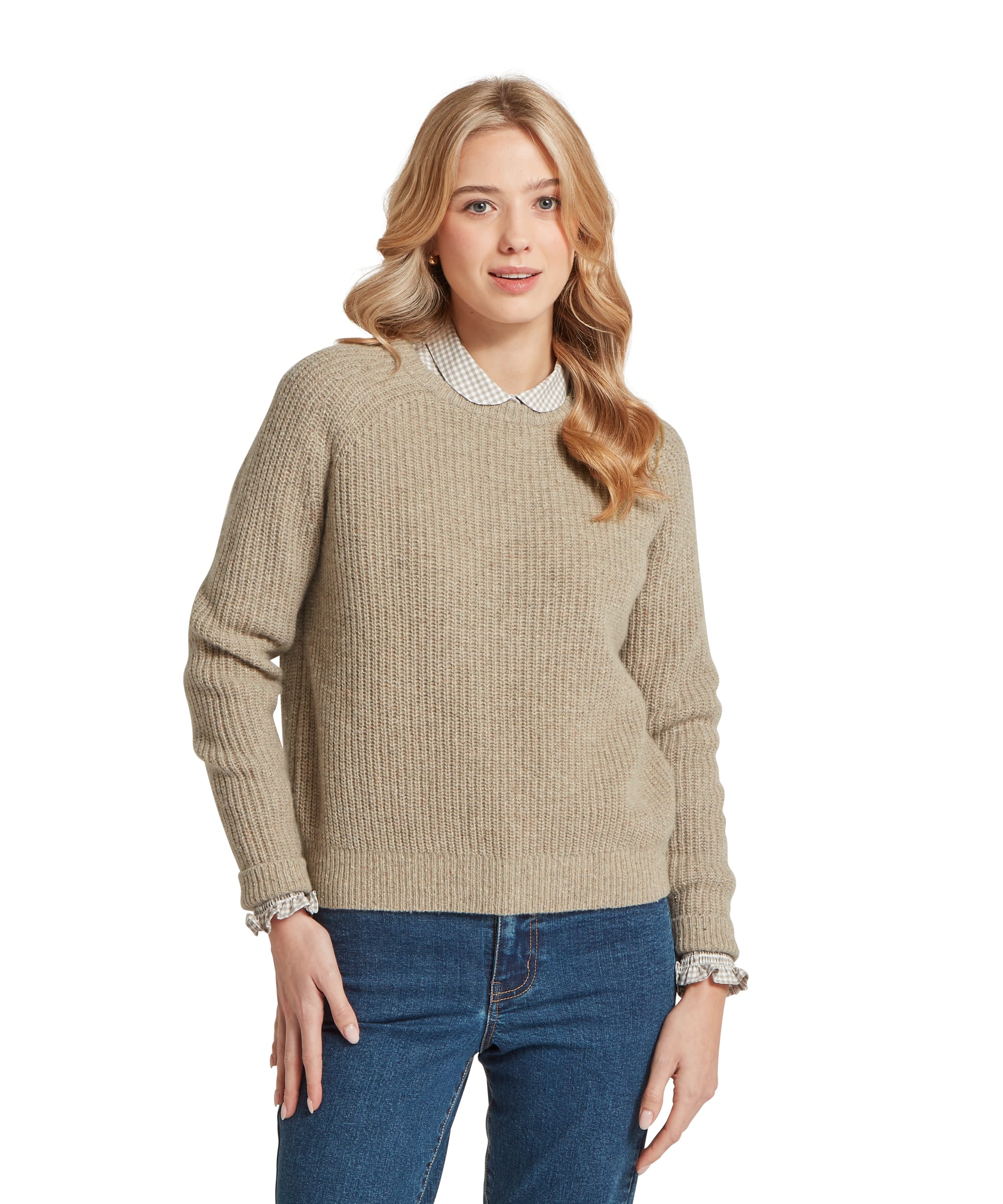 Three-quarter view of a woman wearing the Schöffel Women's Balmaha Jumper in Oatmeal, featuring a chunky rib-knit texture and crew neck, layered over a gingham collared shirt with the collar peeking through, styled with blue jeans