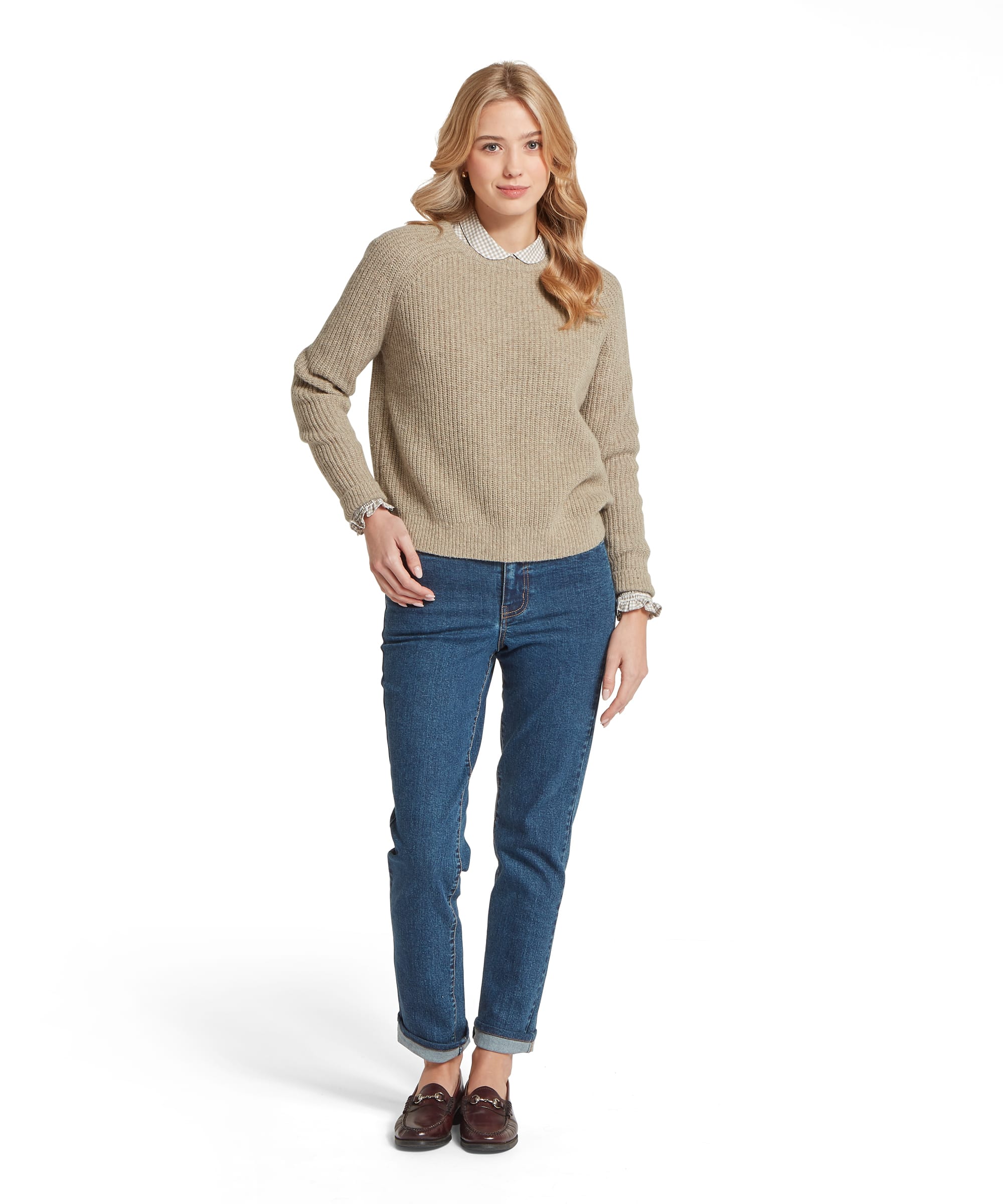 Full-length front view of the Schöffel Women's Balmaha Jumper in Oatmeal, showing the relaxed chunky-rib crew neck silhouette layered over a gingham collared shirt, worn with straight-leg blue jeans and brown horsebit loafers