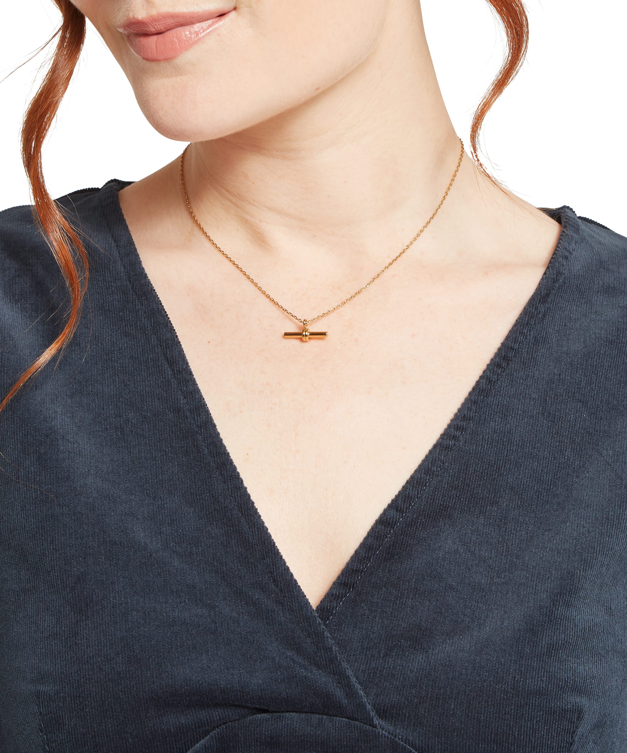 Close-up of the V-neckline on the Schöffel Women's Briar Cord Dress in Navy, showing the soft fine-wale corduroy fabric texture, worn with a gold T-bar necklace for an elegant country look