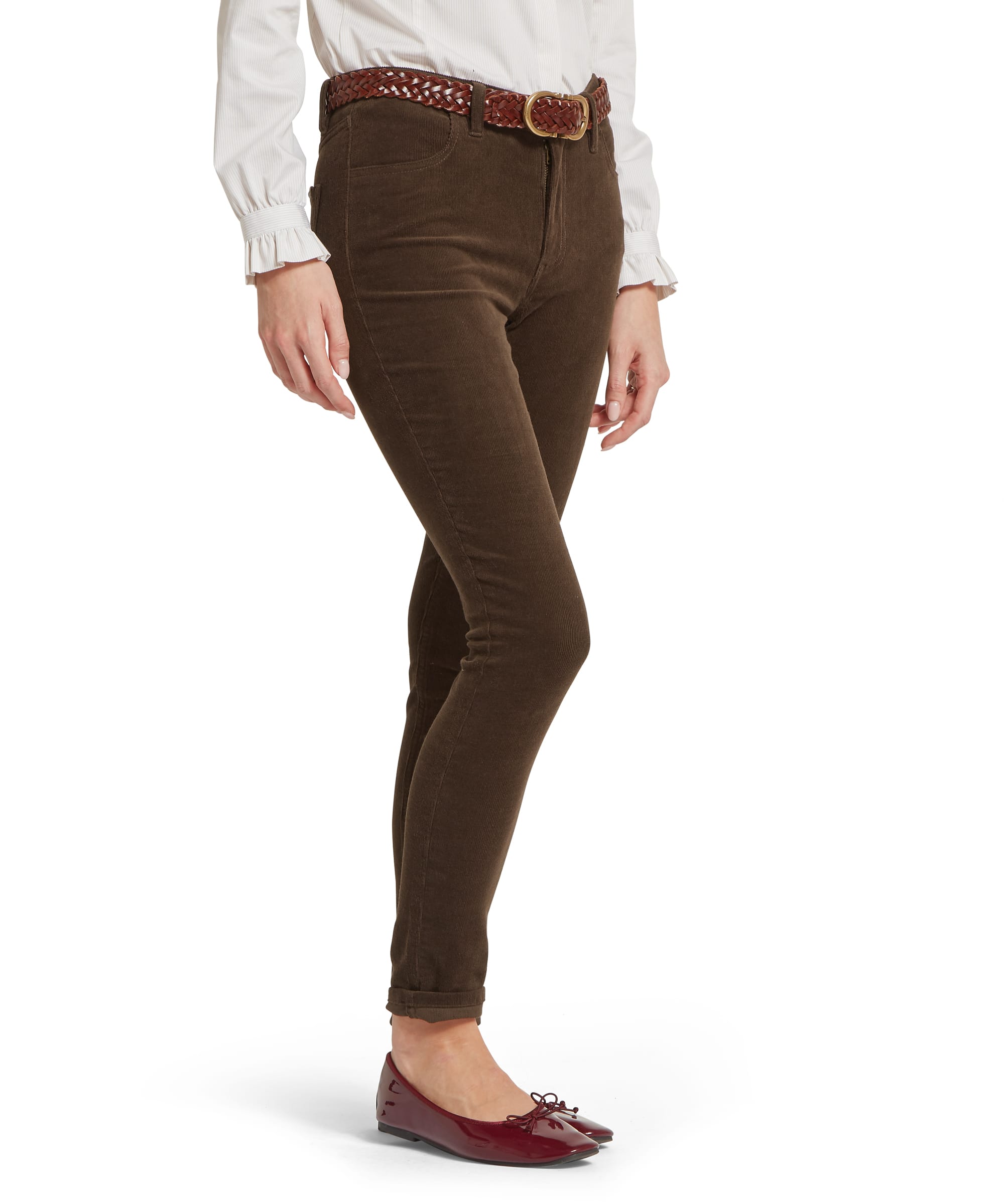 Side view of the Women's Schöffel Clover Cord Jean in tobacco brown needlecord, with a slim-fit silhouette, high rise and turn-up hem, styled with a white frill-cuff blouse, tan plaited leather belt and burgundy patent ballet flats.