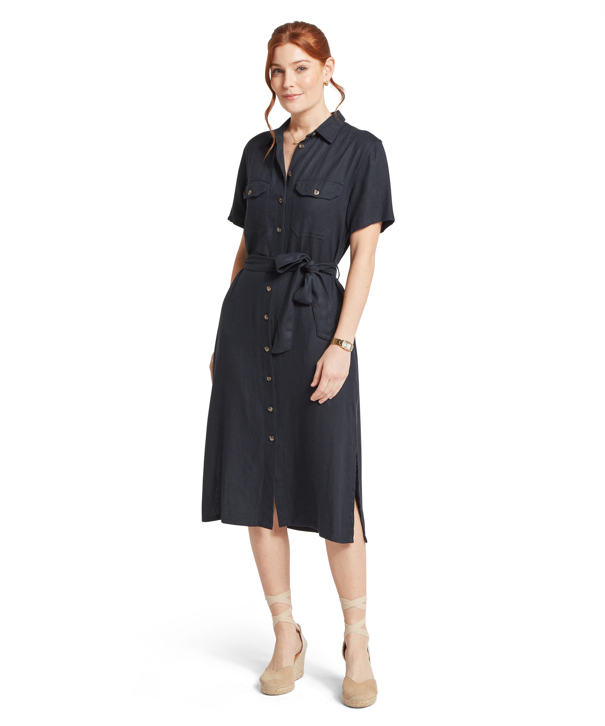 Woman wearing a navy dress with a belt on a white background