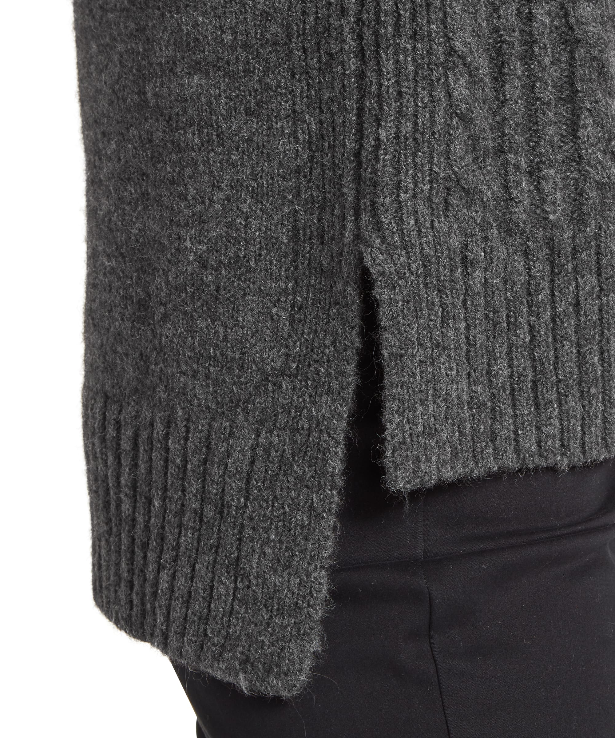 Close-up detail of the Schöffel Women's Evie Sleeveless Jumper in charcoal grey, highlighting the chunky cable-knit texture, ribbed hem, and split side seam worn over black trousers