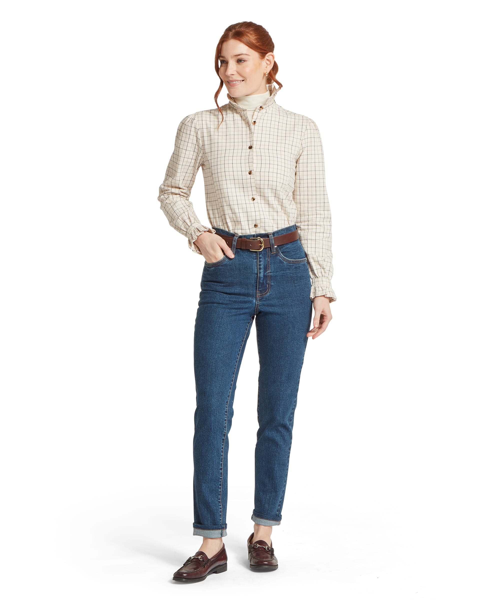 Schöffel Women's Ivy Jean in mid blue denim, full-length front view with turned-up hem and straight leg cut, worn with a cream windowpane-check blouse, brown leather belt, and dark burgundy horsebit loafers