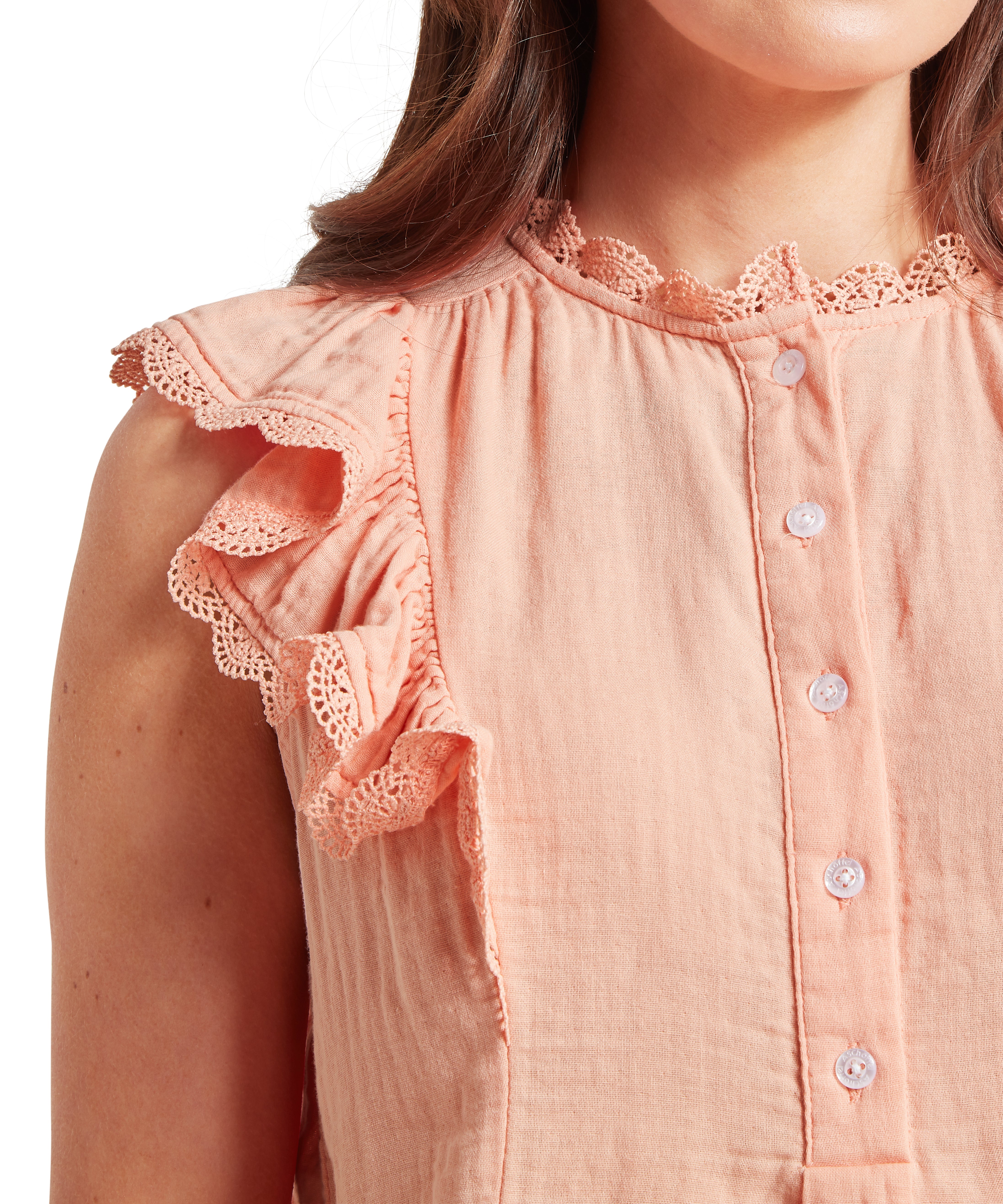 Upper portion of a woman wearing a sleeveless peach-coloured blouse with a crinkled texture and decorative lace trim around the armholes and neckline. The blouse features ruffled sleeves and a button-through front with small white buttons. Displayed against a plain white background.