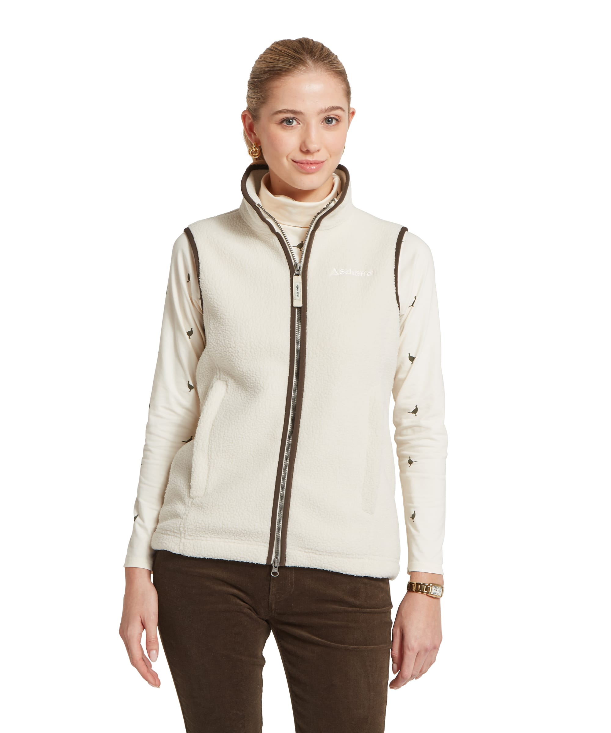 Women's Schöffel Lyndon Retro Fleece Gilet in ecru white, featuring a deep pile sherpa fleece body with dark brown contrast zip and trim, worn over the cream pheasant print Malham Top with dark olive cord trousers.