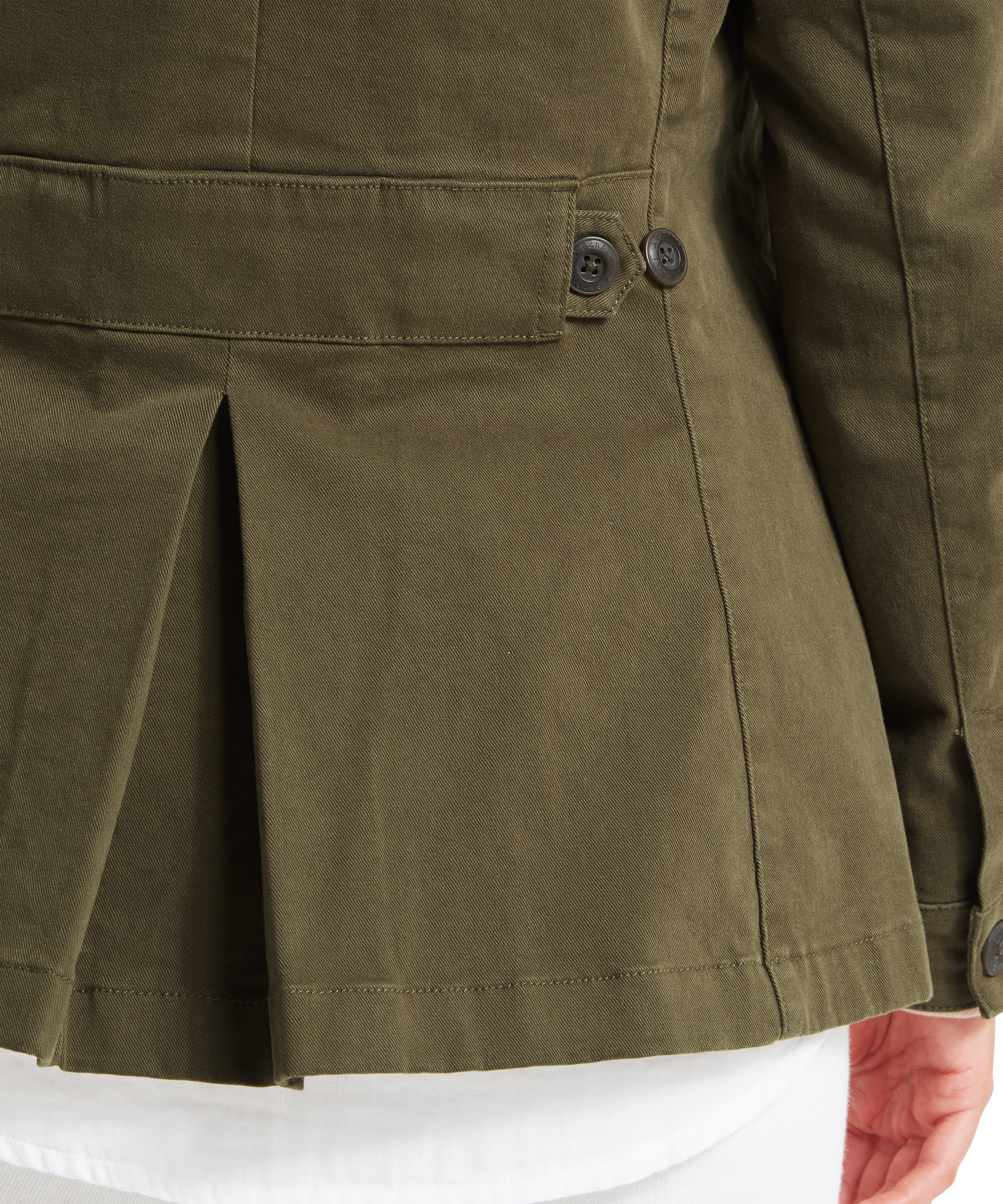 Close-up of the back of an olive green jacket made from textured fabric, featuring a pleated design at the lower back and a horizontal strap detail with two dark buttons near the waistline. A button is also visible near the sleeve cuff.