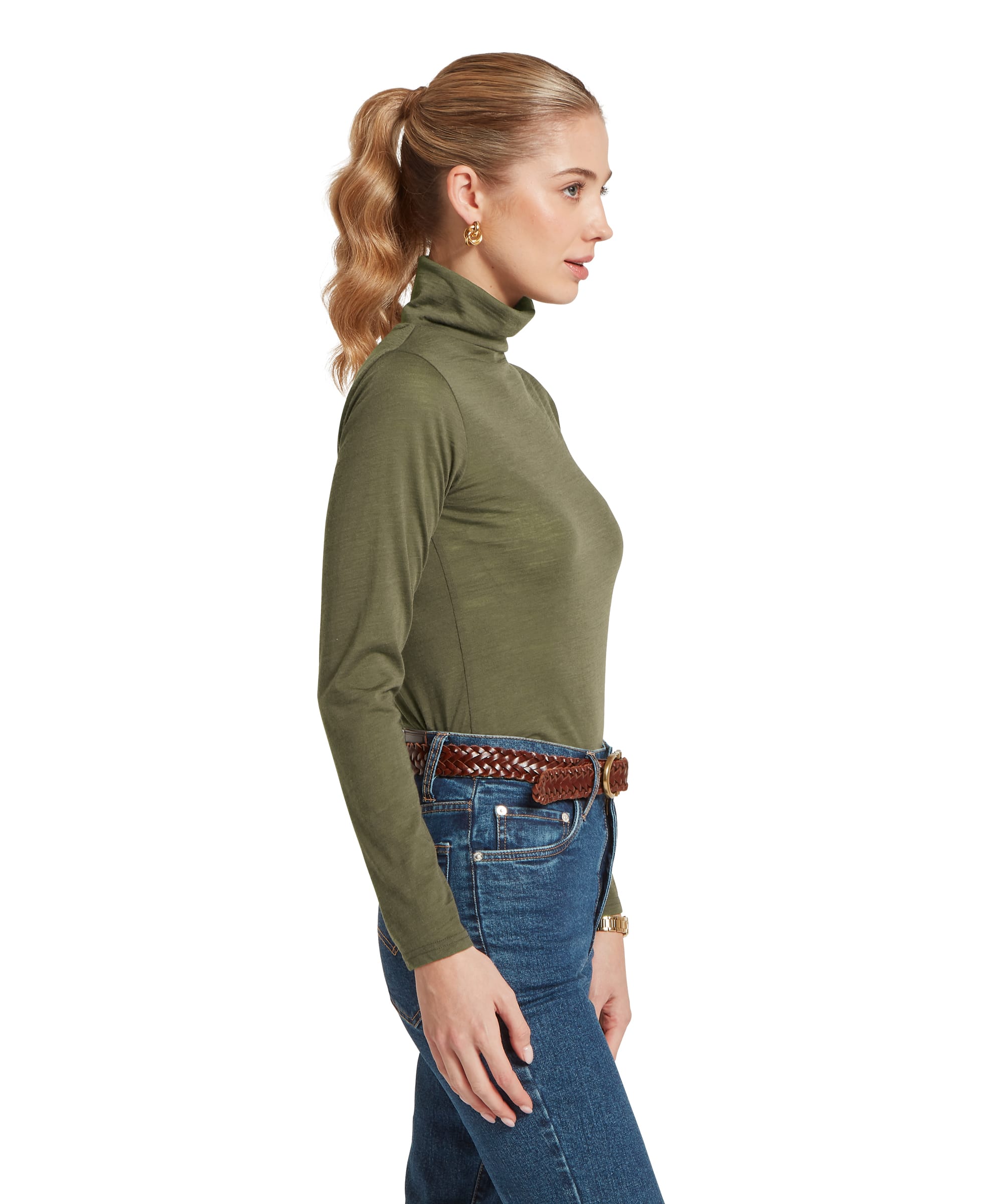 Side profile of a woman wearing the Schöffel Women's Malton Merino Roll Neck Top in Khaki Green, highlighting the slim silhouette, soft merino fabric drape and neat rolled collar