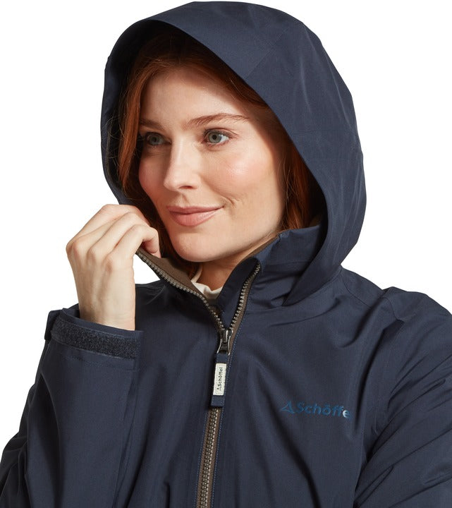 Schöffel Manton women's lightweight jacket in navy, close-up of woman wearing hood up with full-length zip and embroidered logo