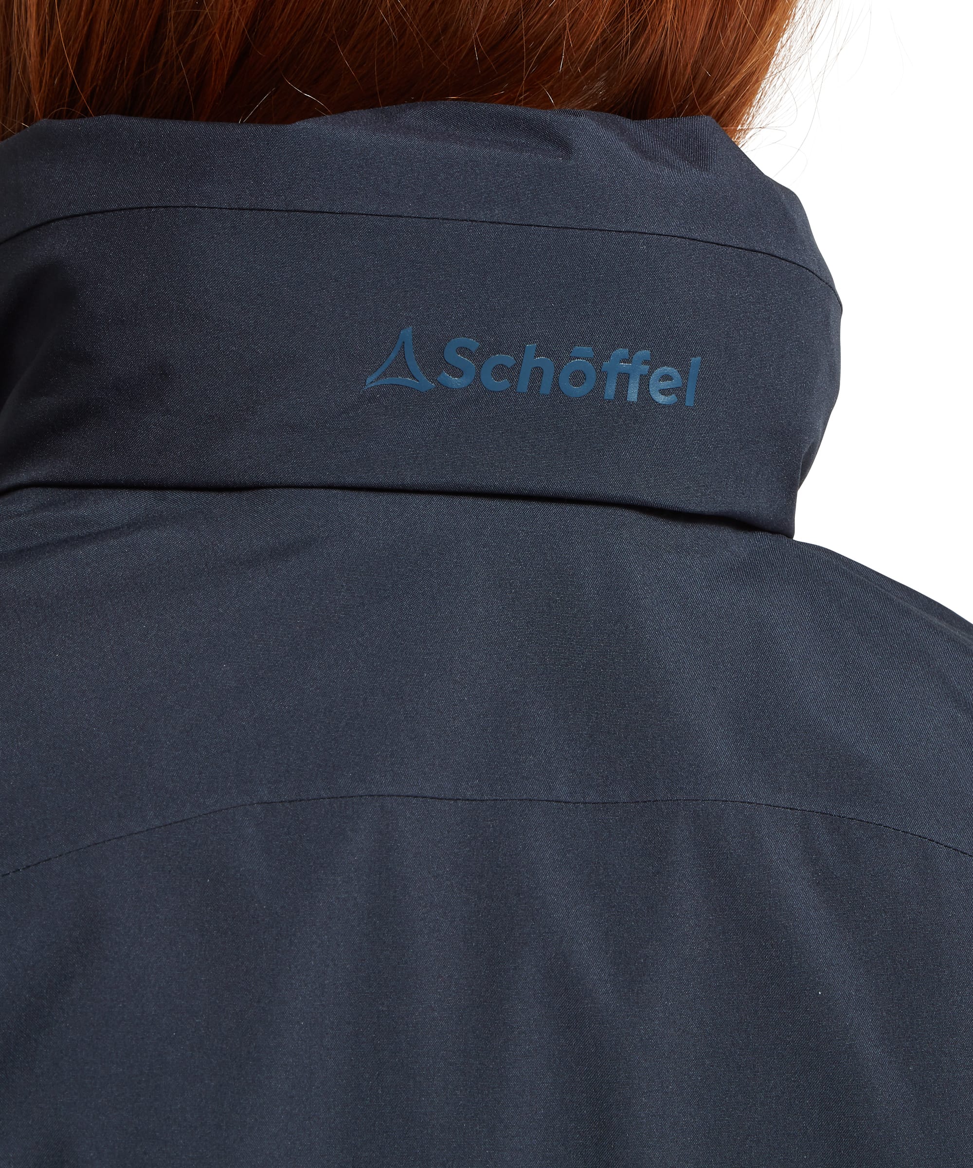 Close-up rear detail of the Women's Schöffel Manton Lightweight Waterproof Jacket in midnight navy, highlighting the tonal Schöffel embroidered logo at the back collar and the smooth waterproof shell fabric construction.
