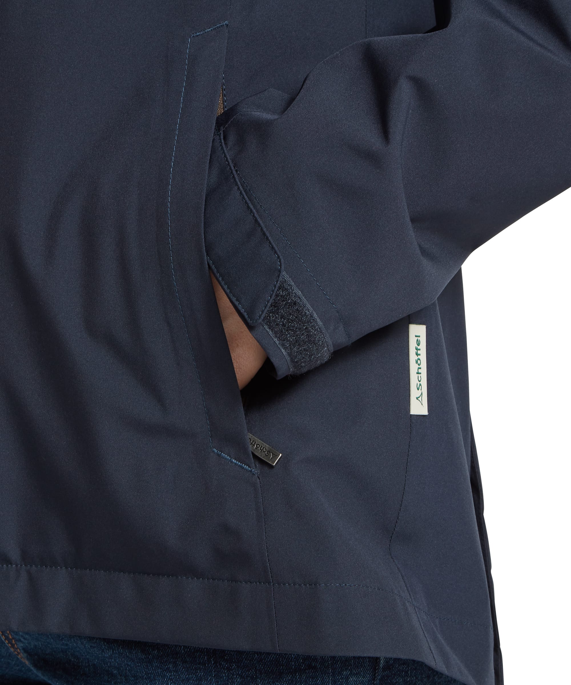 Detail of the side hand-warmer pocket and adjustable velcro cuff on the Schöffel Women's Manton Lightweight Waterproof Jacket in Navy, highlighting the Schöffel woven label and practical pocket construction