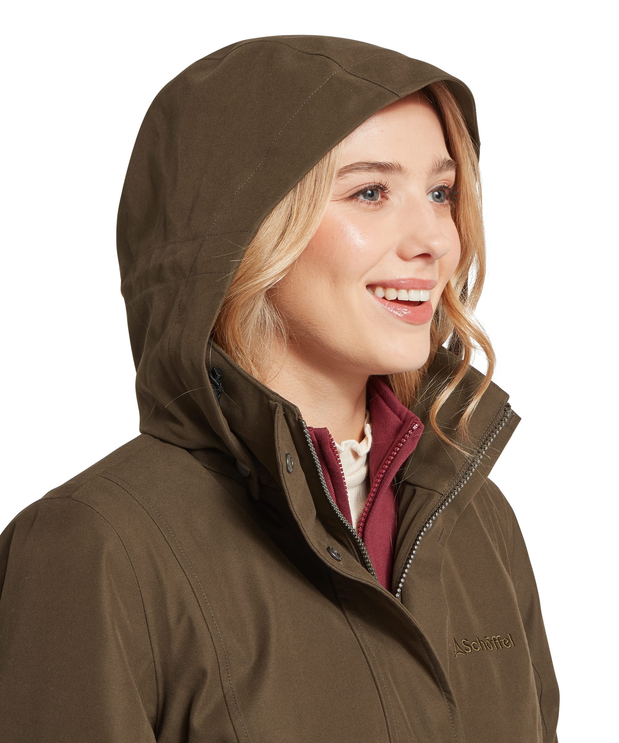 Close-up of the structured waterproof hood on the Schöffel Women's Marefield Coat in Dark Olive, showing the Schöffel branding, storm collar construction and layering over a burgundy fleece mid-layer and cream base layer
