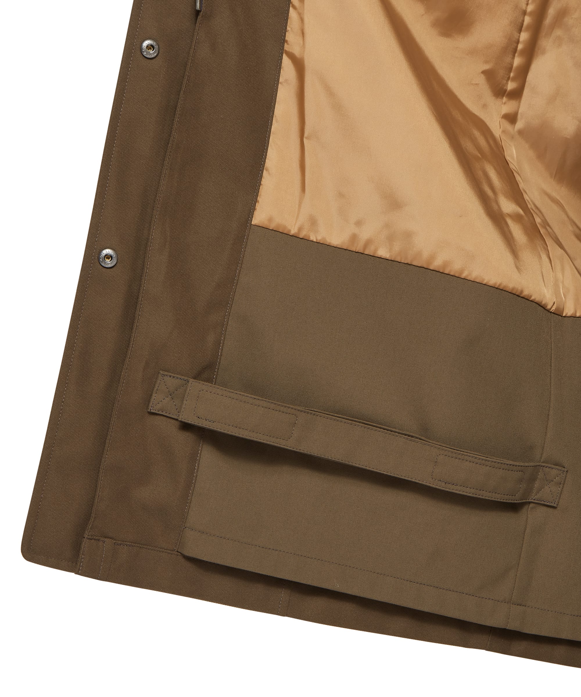 Interior hem close-up of the Schöffel Women's Marefield Waterproof Coat in khaki green, showing the caramel satin lining, lower hem tab fastening, press-stud placket edge, and coat hem construction detail on a plain background
