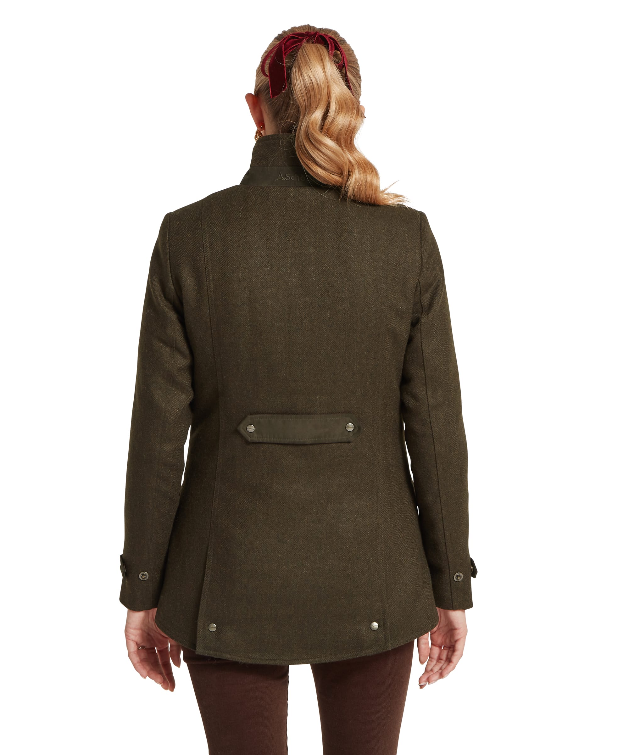 Back view of the Schöffel Women's Murra Tweed Coat in Dark Olive Herringbone, showing the Schöffel branded back collar, back vent with snap detail, shaped hem and button-tab cuffs, worn over dark cord trousers