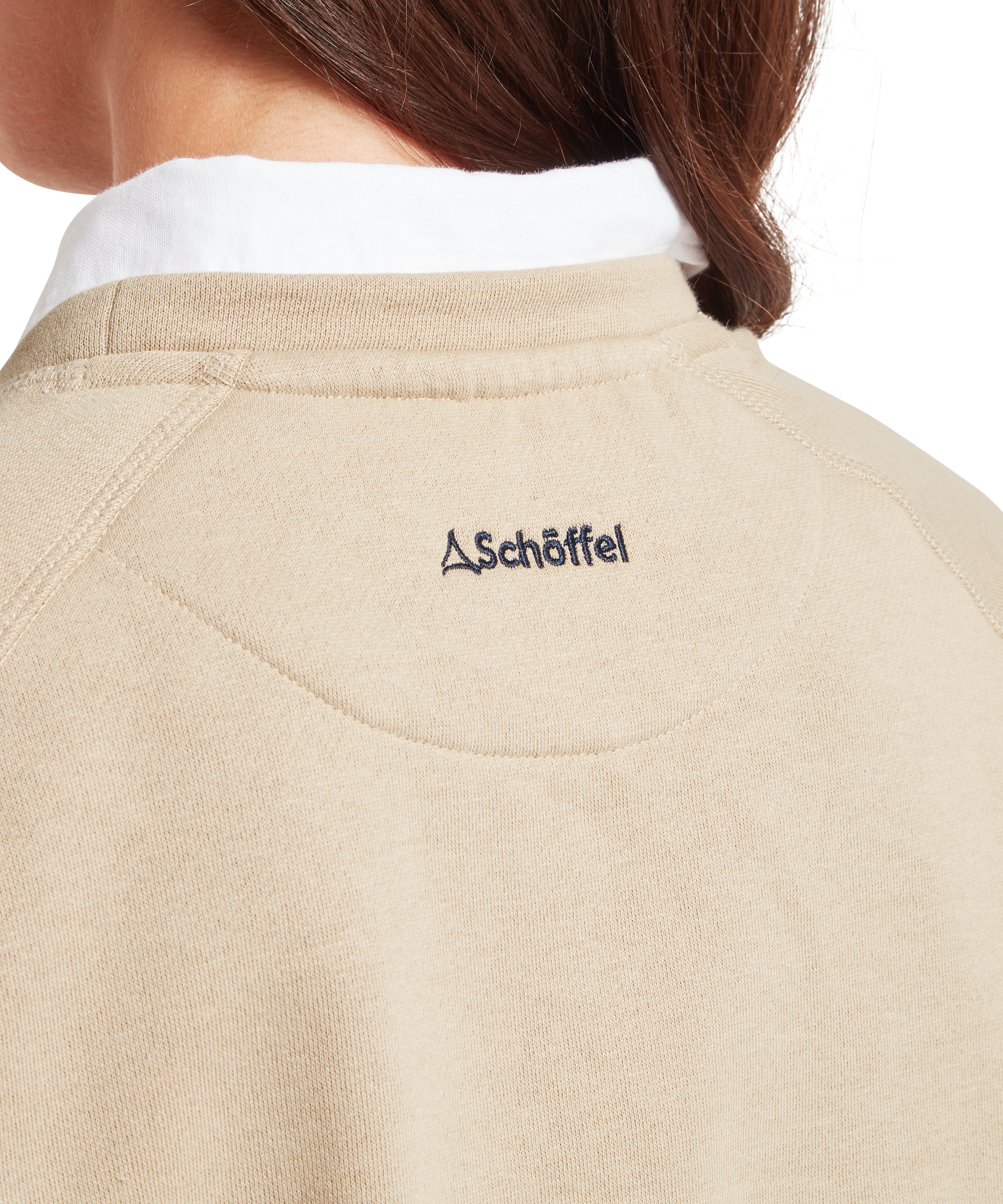 Close up of the back of a beige sweatshirt with Schöffel logo on a white background