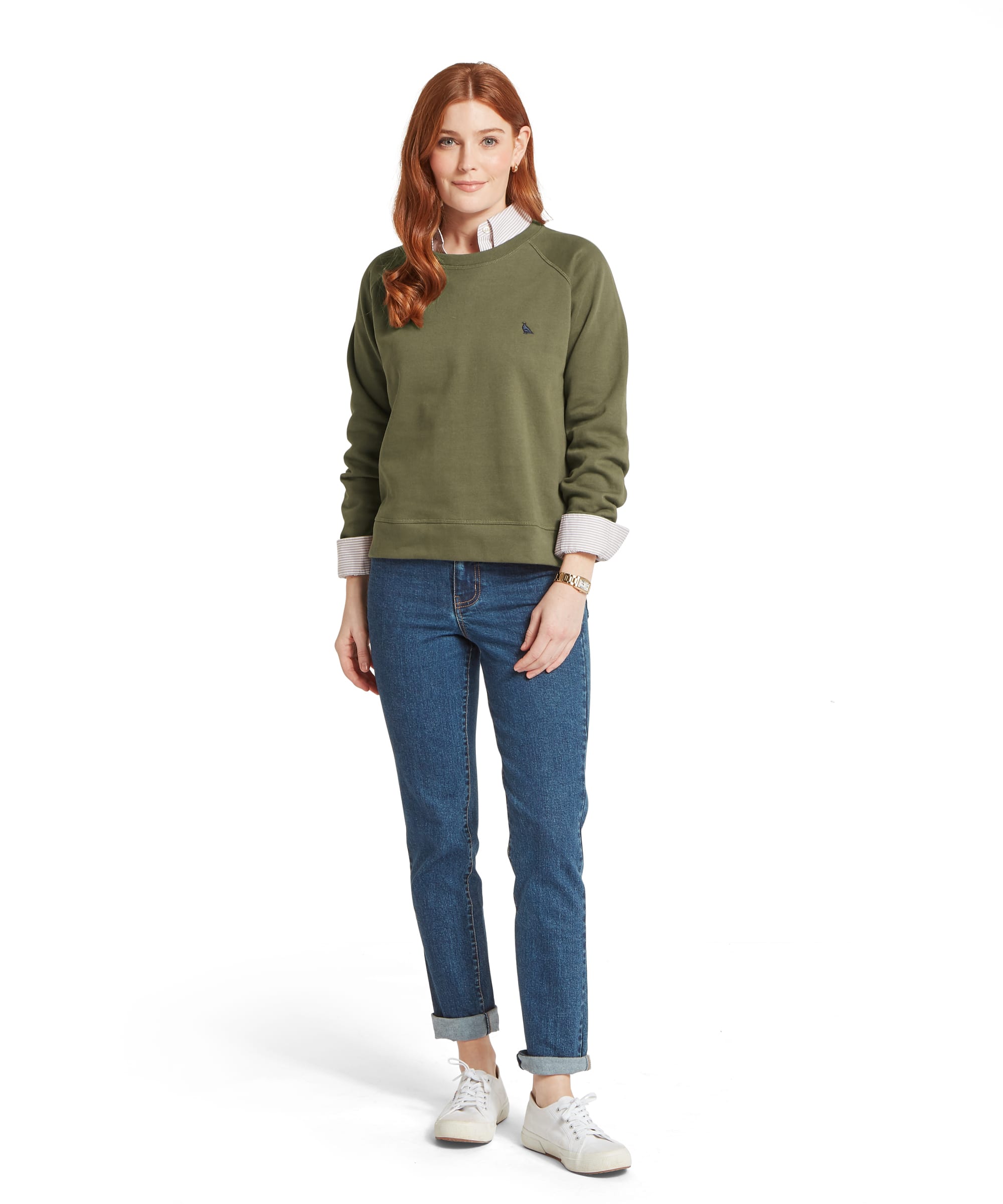 Full-length view of the Schöffel Women's Newberry Sweatshirt in Khaki Green worn with a classic striped shirt, blue turn-up jeans and white trainers, showcasing the relaxed yet smart country styling