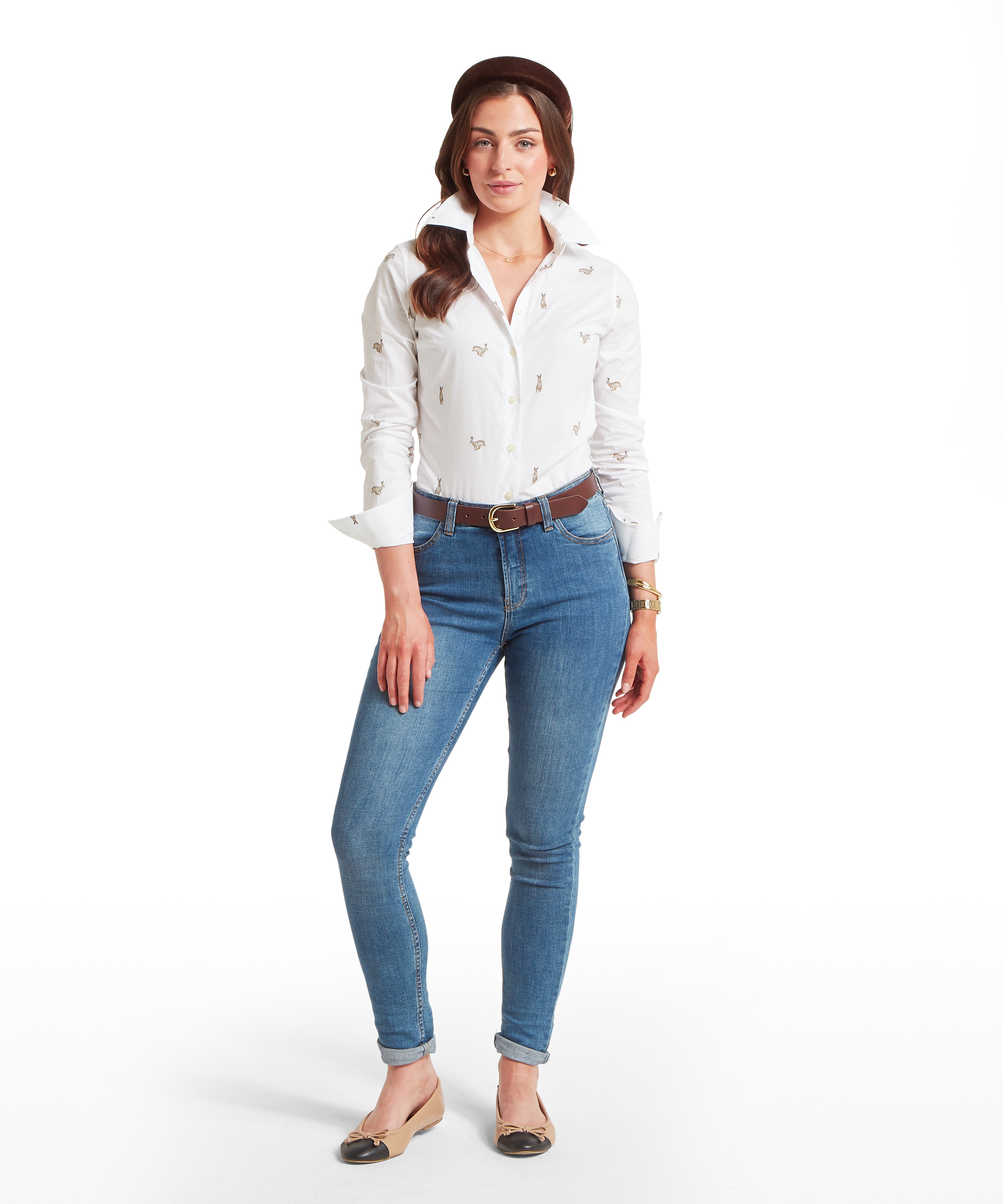 White long-sleeve fitted button-up shirt with a collar, featuring a repeating hare pattern in various poses. The shirt is paired with blue jeans and a brown belt.