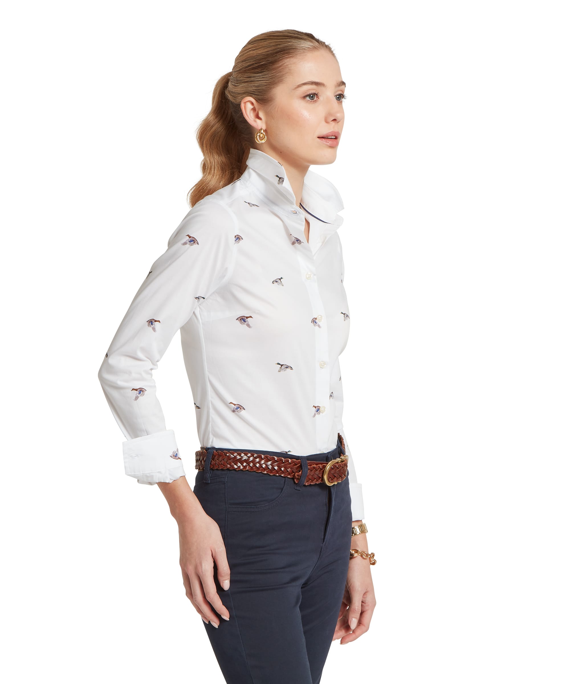 Woman wearing a white blouse with small patterns and dark pants on a white background