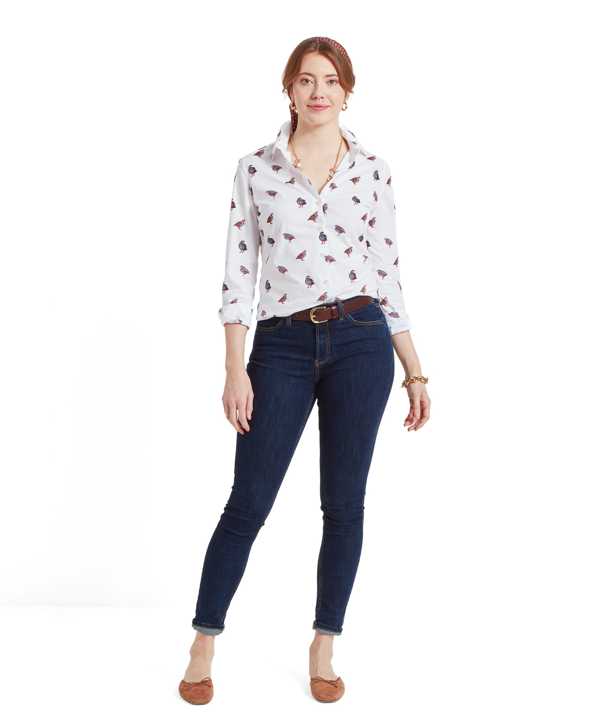 Full body view of a woman wearing a Schöffel Norfolk Shirt for Womens in Brown White with a partridge bird pattern, paired with dark blue skinny jeans and brown flats. She is standing with a relaxed posture, her hands resting in her pockets.