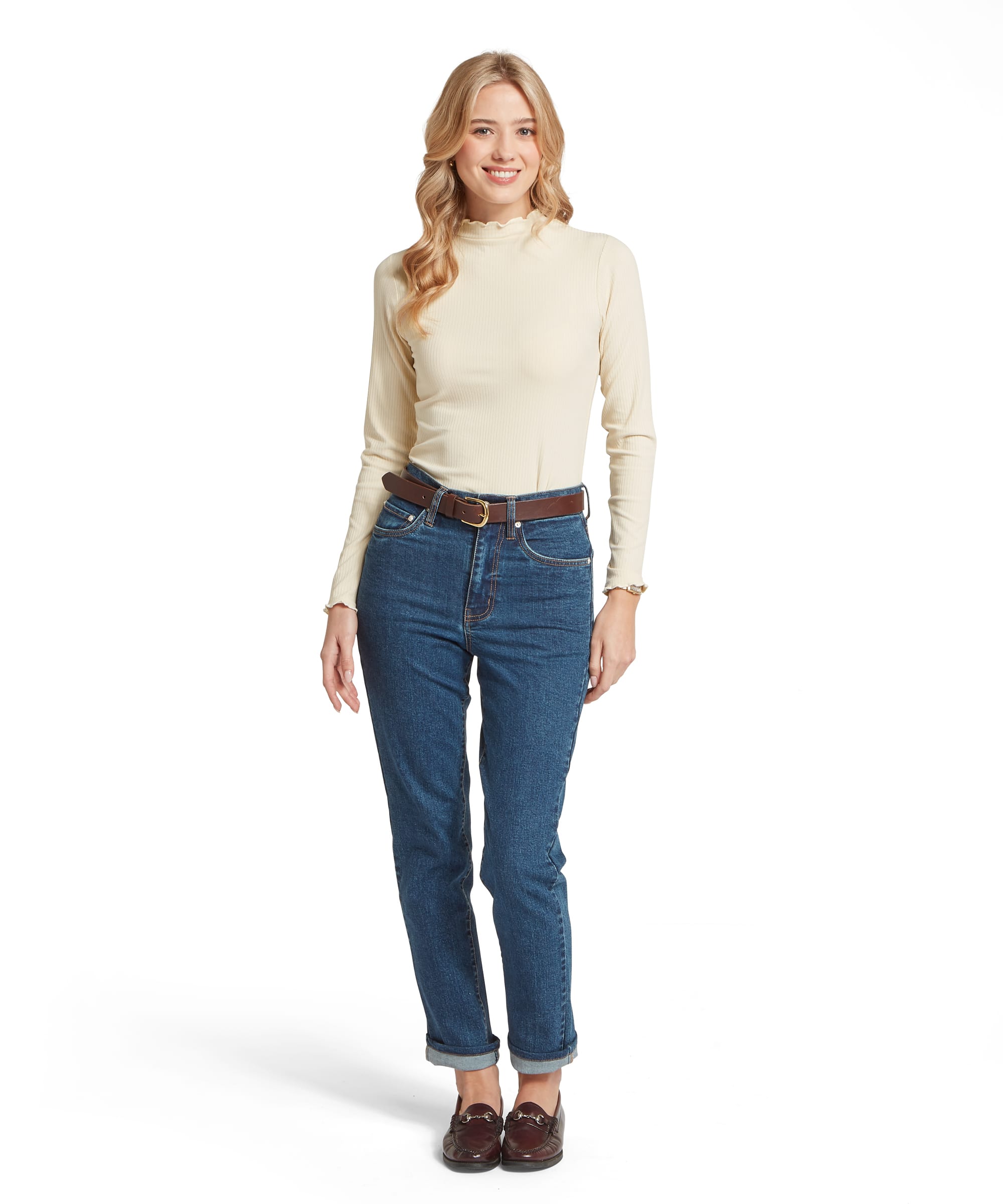 Full-length front view of the Schöffel Women's Roseberry Ribbed Polo Neck Top in Oatmeal, worn with straight-leg blue jeans, a tan leather belt and burgundy horsebit loafers for an effortlessly polished country look