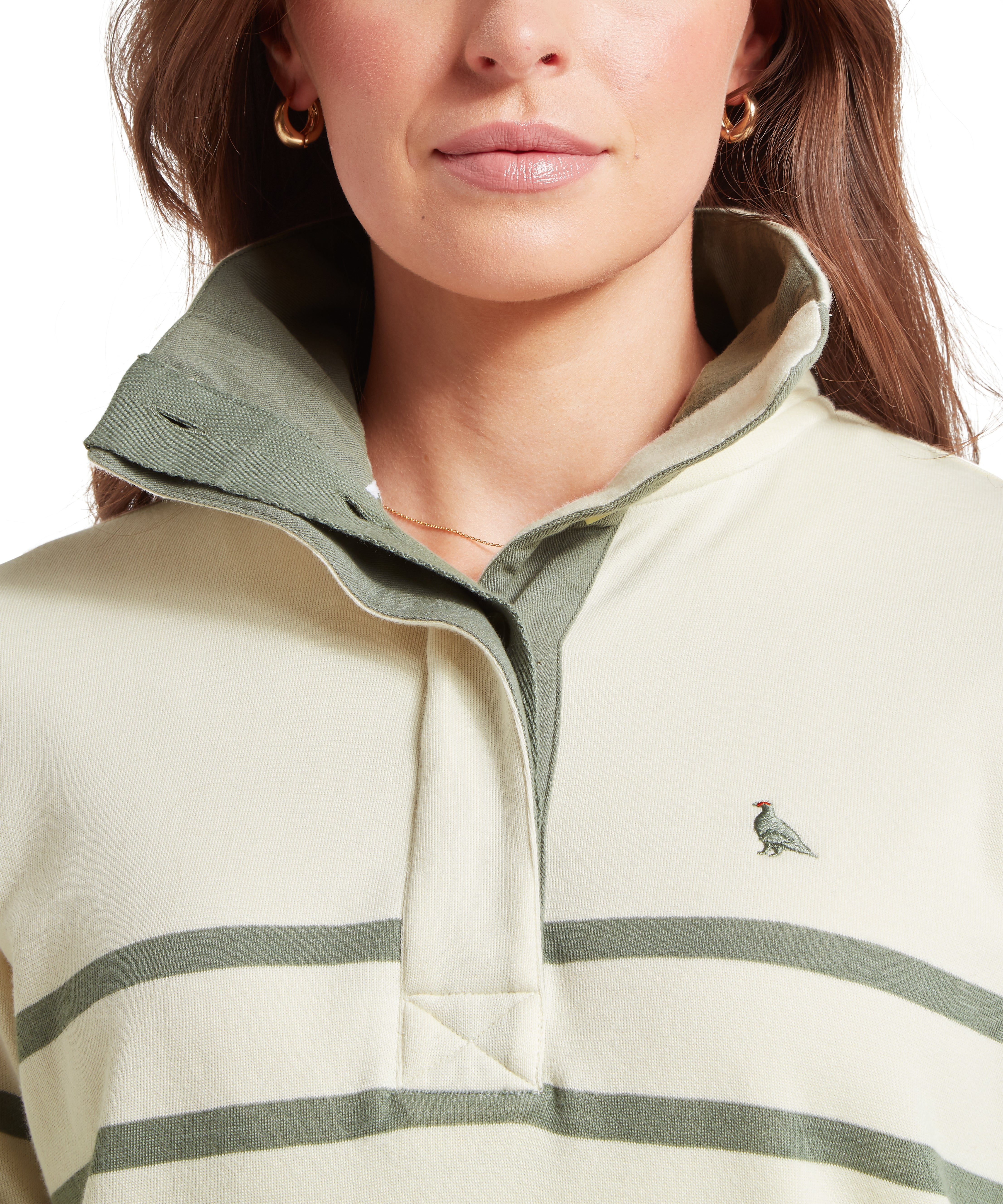 Close-up of a woman wearing  a green and cream striped sweatshirt featuring a green ptarmigan logo